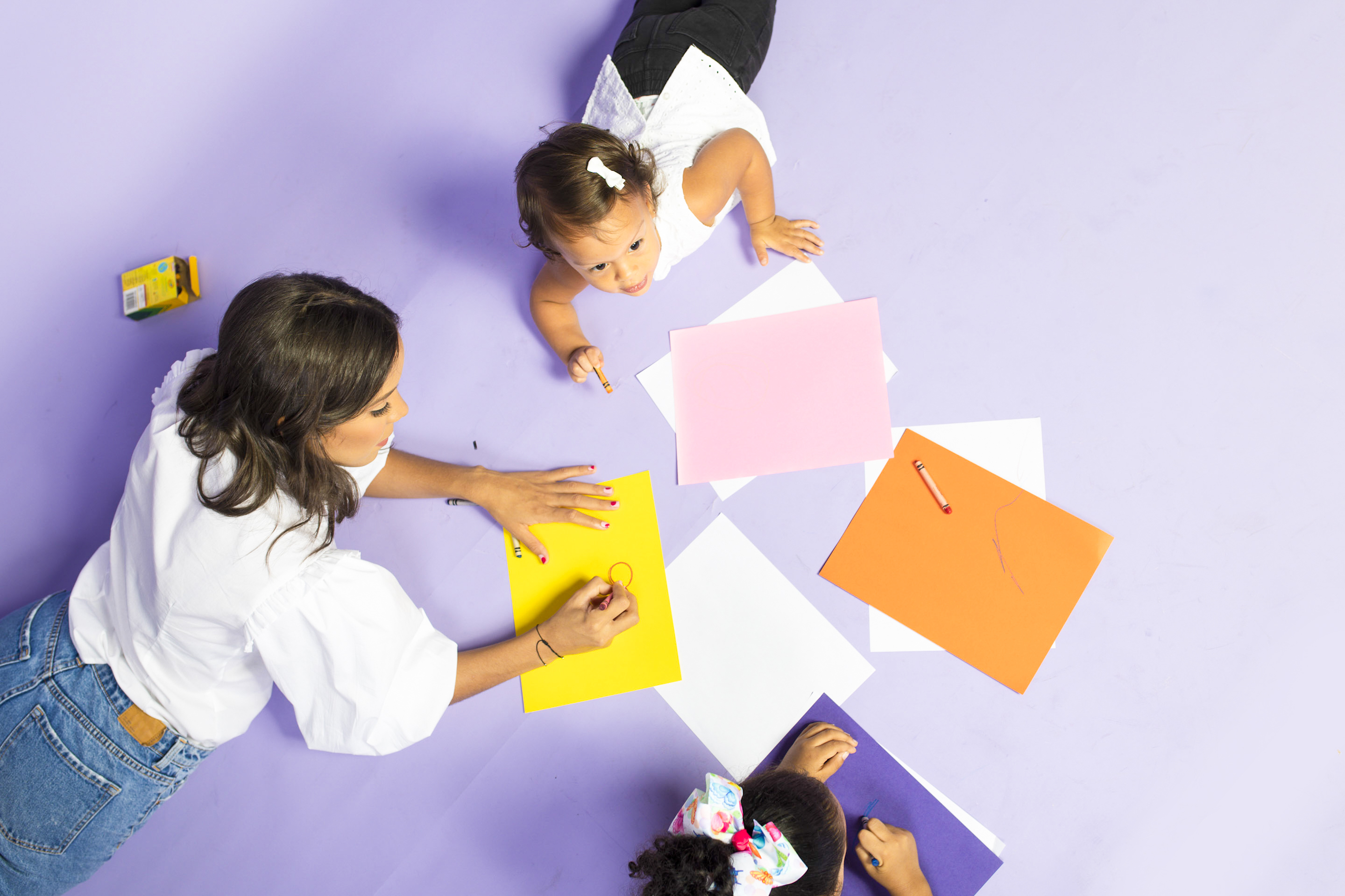 Natalia and young children drawing together with crayons