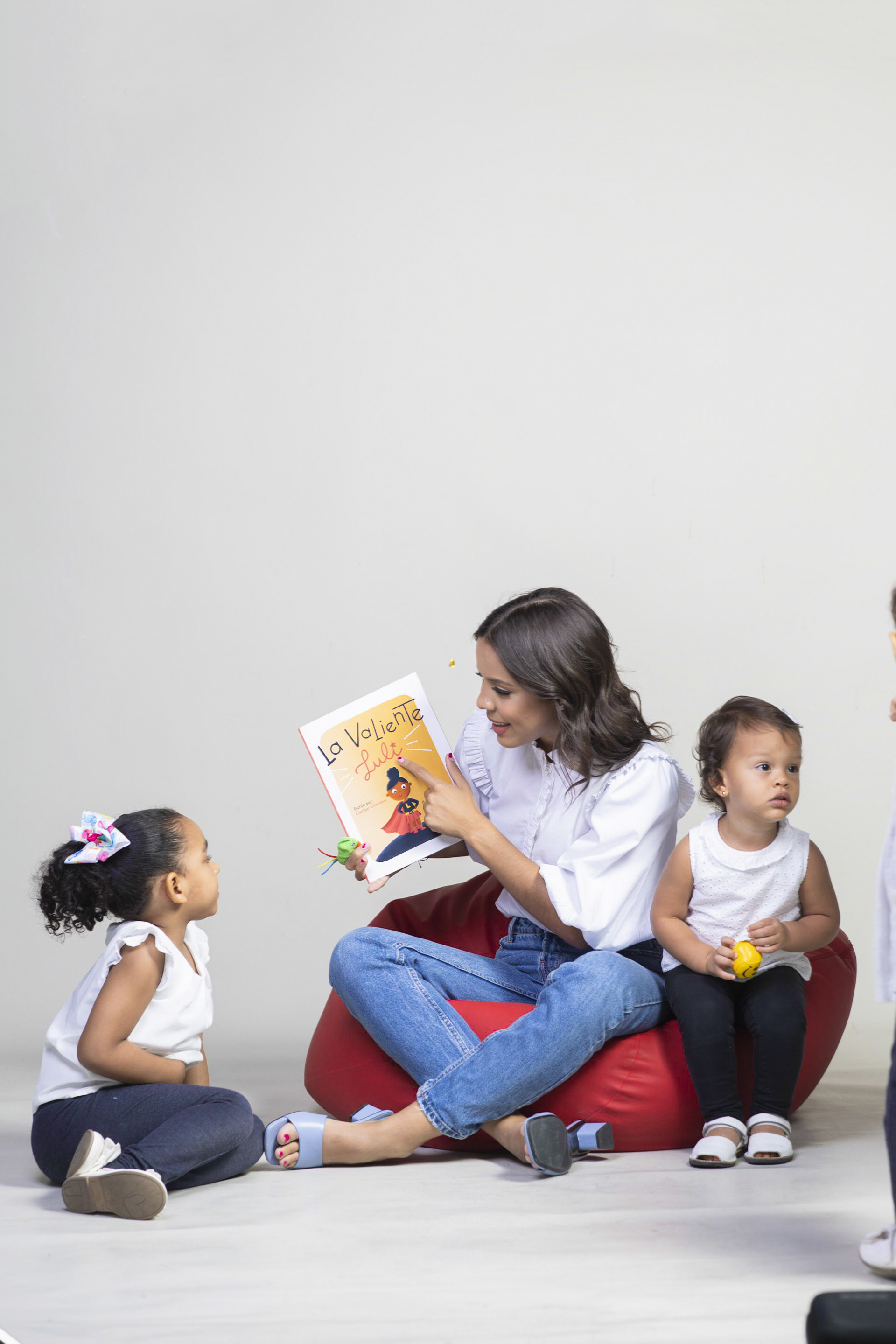 Natalia reading a picture book with two young children