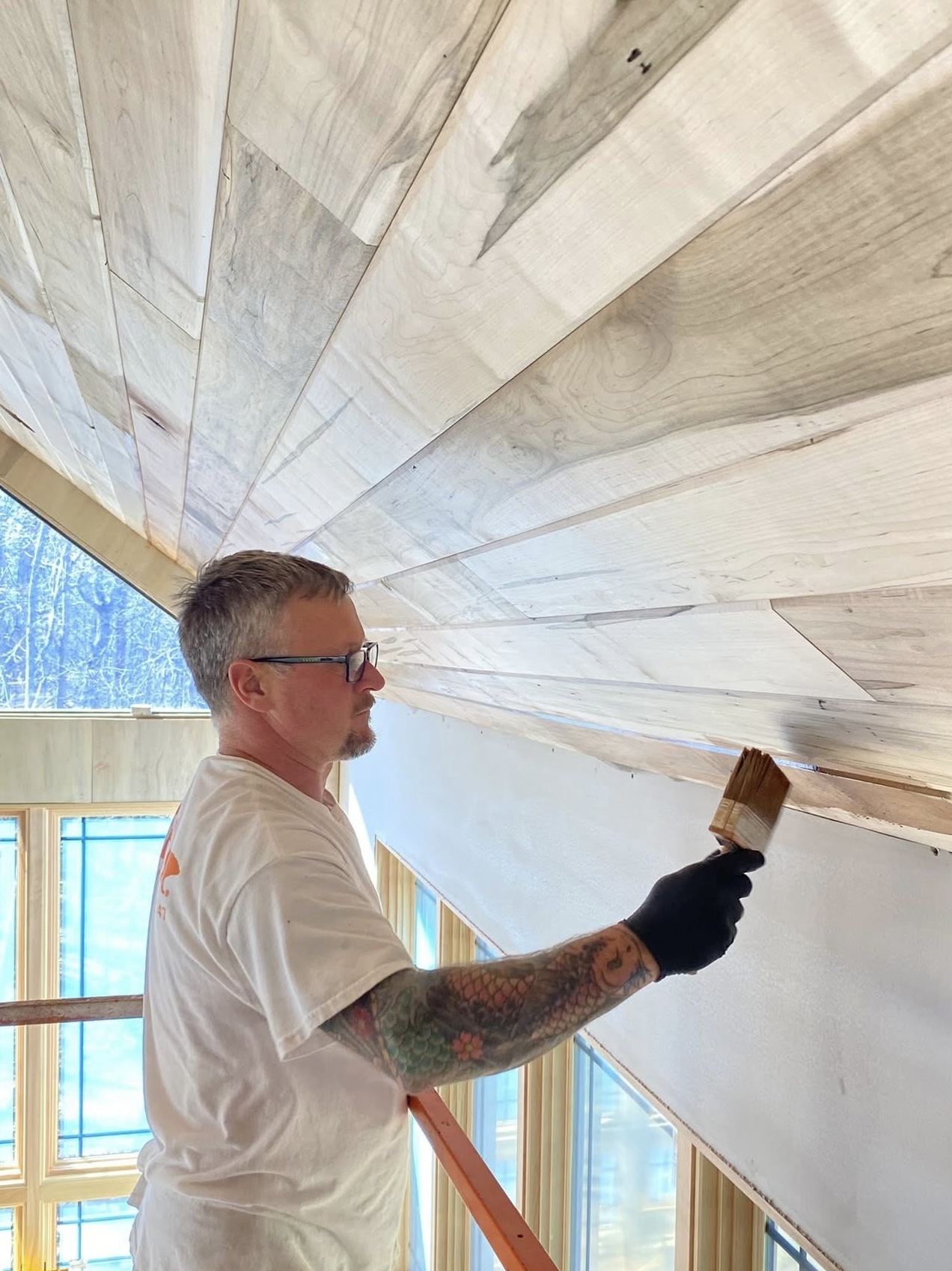 Journey's Handyman painter staining a wood plank ceiling in North Georgia