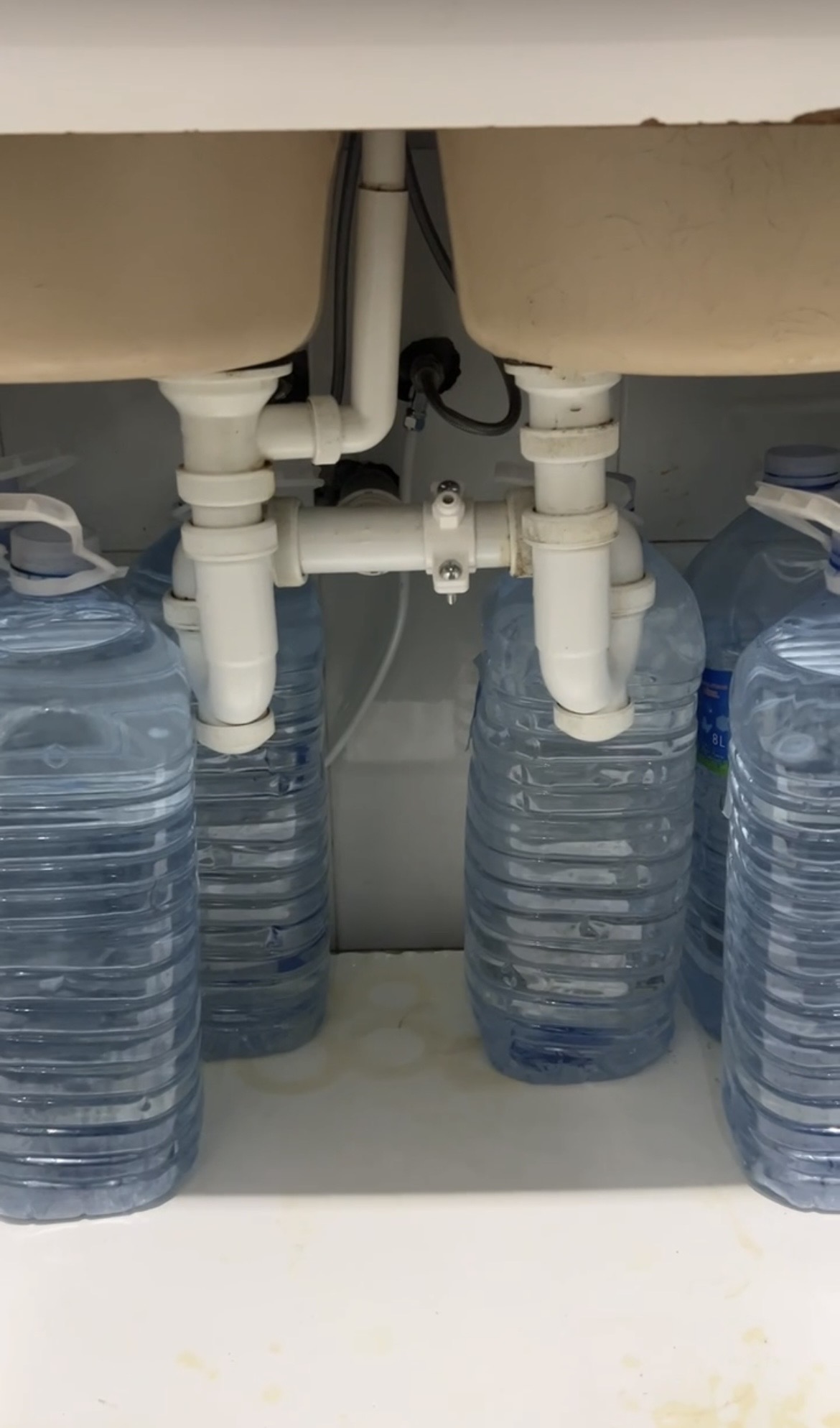 Garrafas de agua bajo fregadero