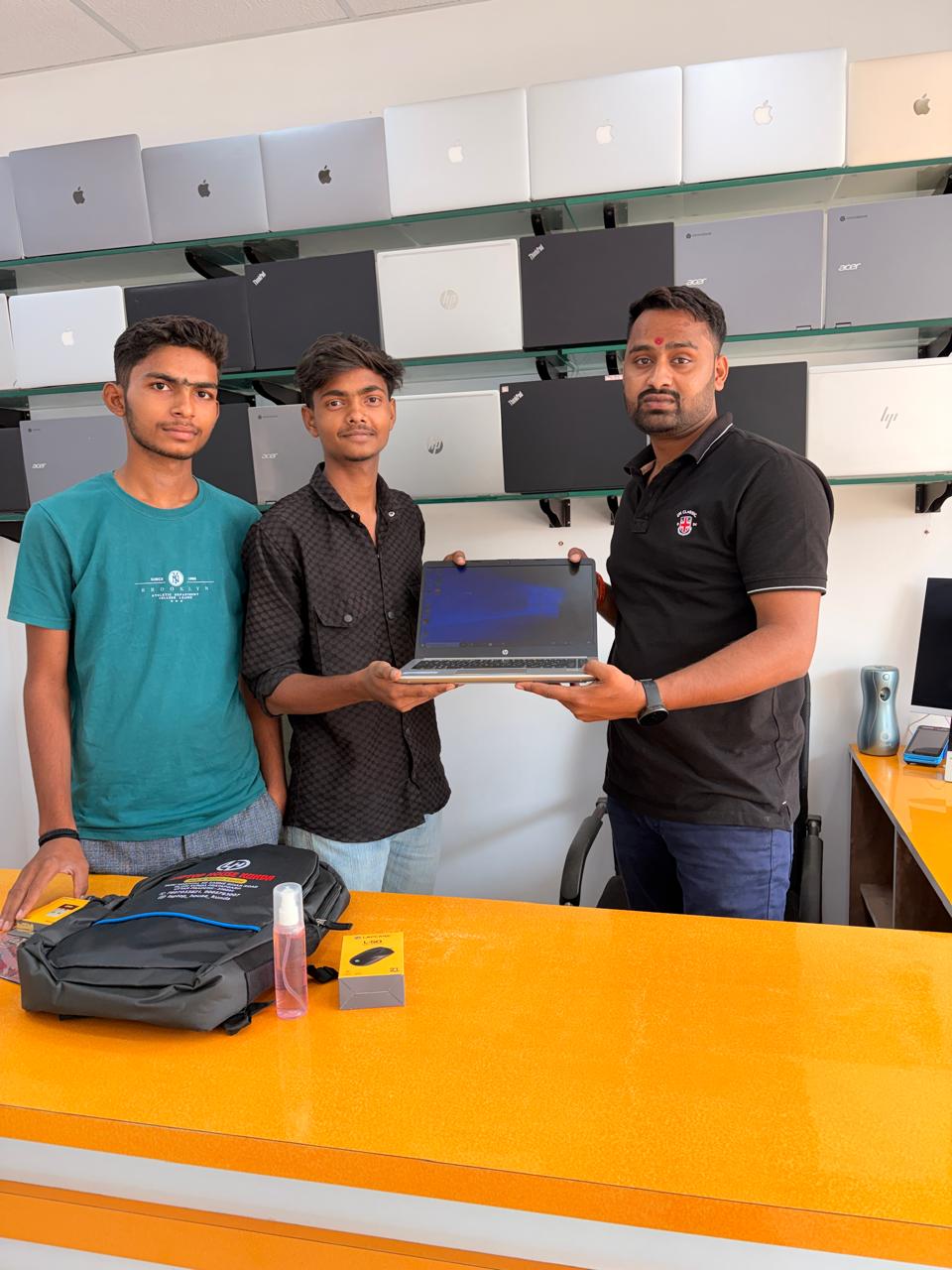 Handing over a fresh HP laptop with a Laptop House Kunda backpack — happy customer walked out ready-to-use.