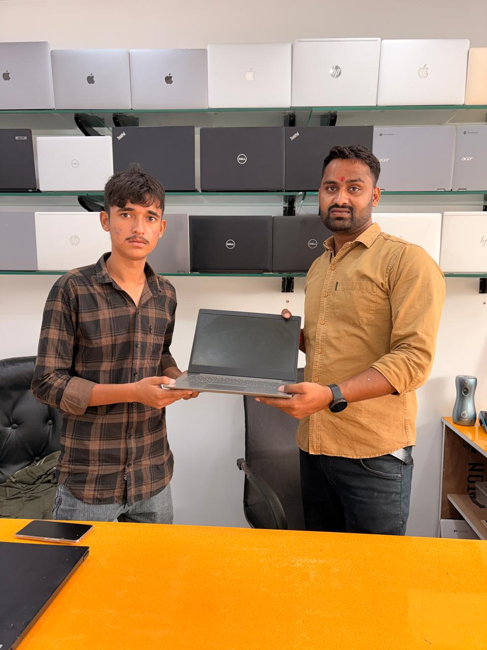 Young student picked up his first laptop from our shelf — sorted for college and studies.