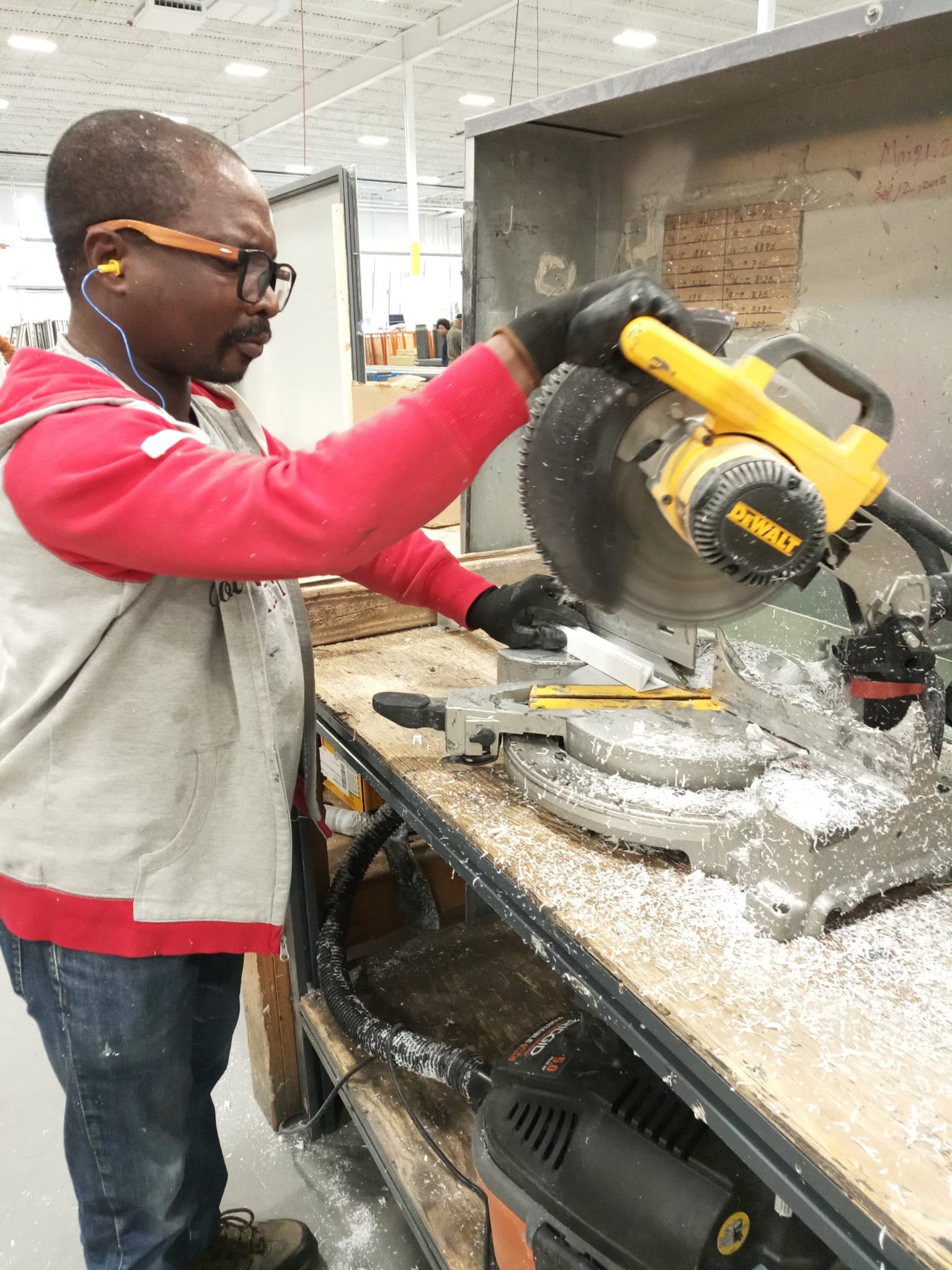 Victor Kwawukume working with a mitre saw in a Canadian workshop