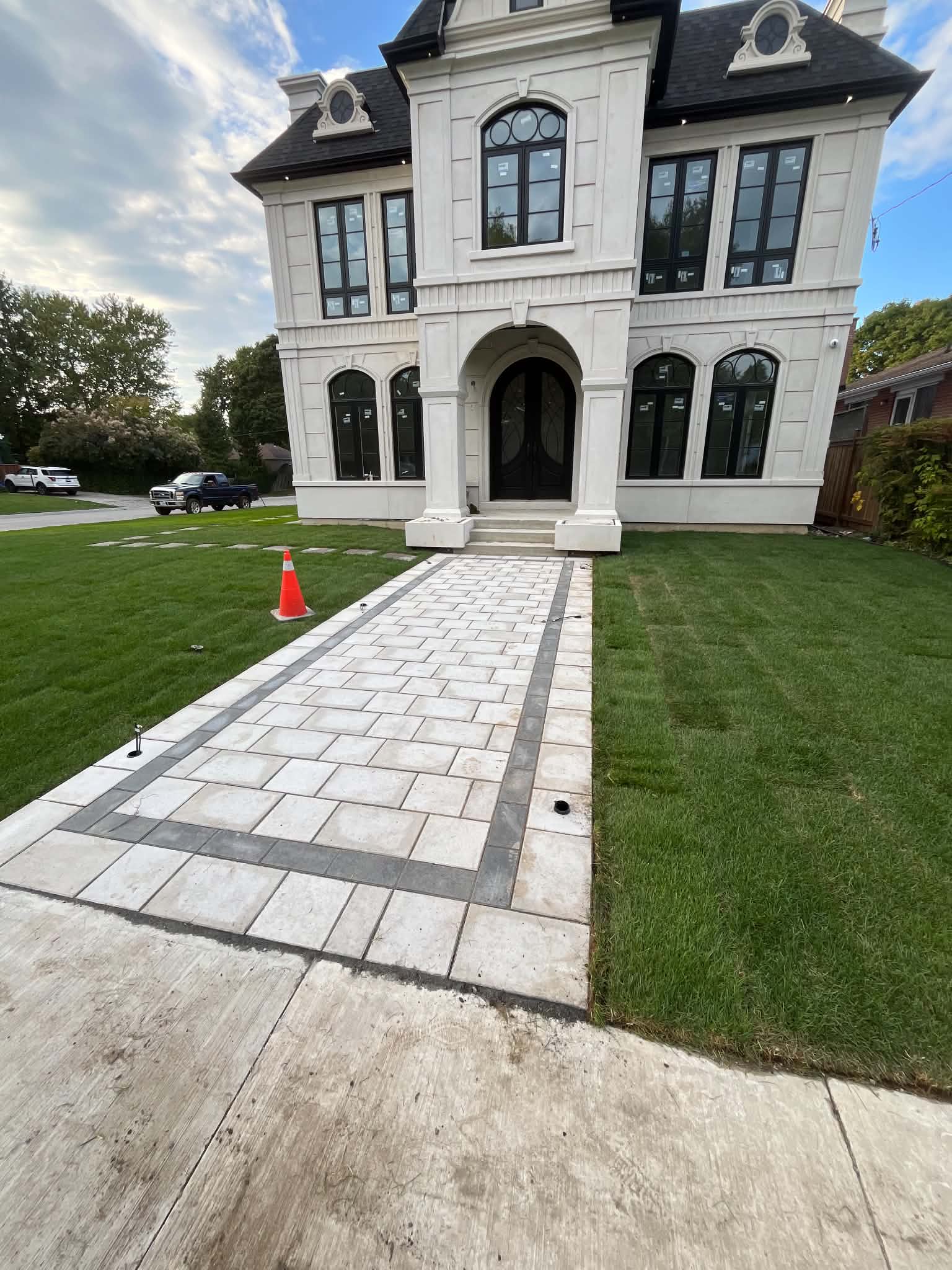 Luxury home with custom interlock walkway and fresh striped sod — high-end landscaping in the GTA