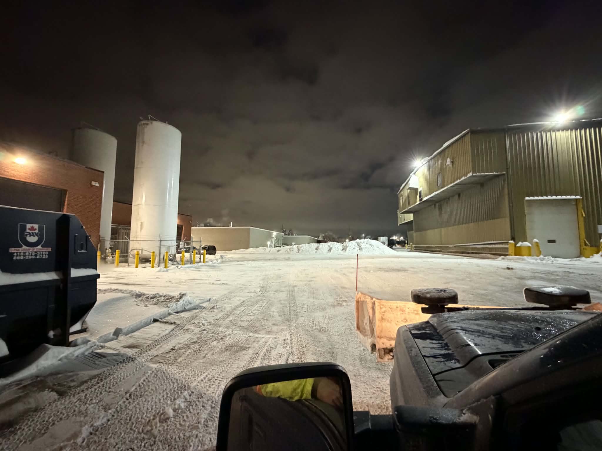 Commercial snow plowing at night — Freedom North truck clearing an industrial lot