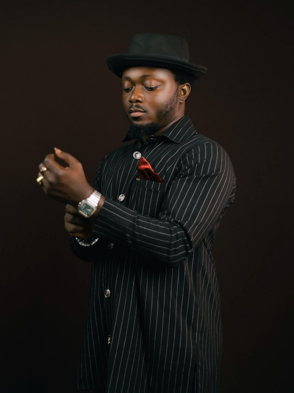 Pastor White in a black pinstripe outfit and signature hat — the modern formal portrait of the Founder of White Outreach Movement.