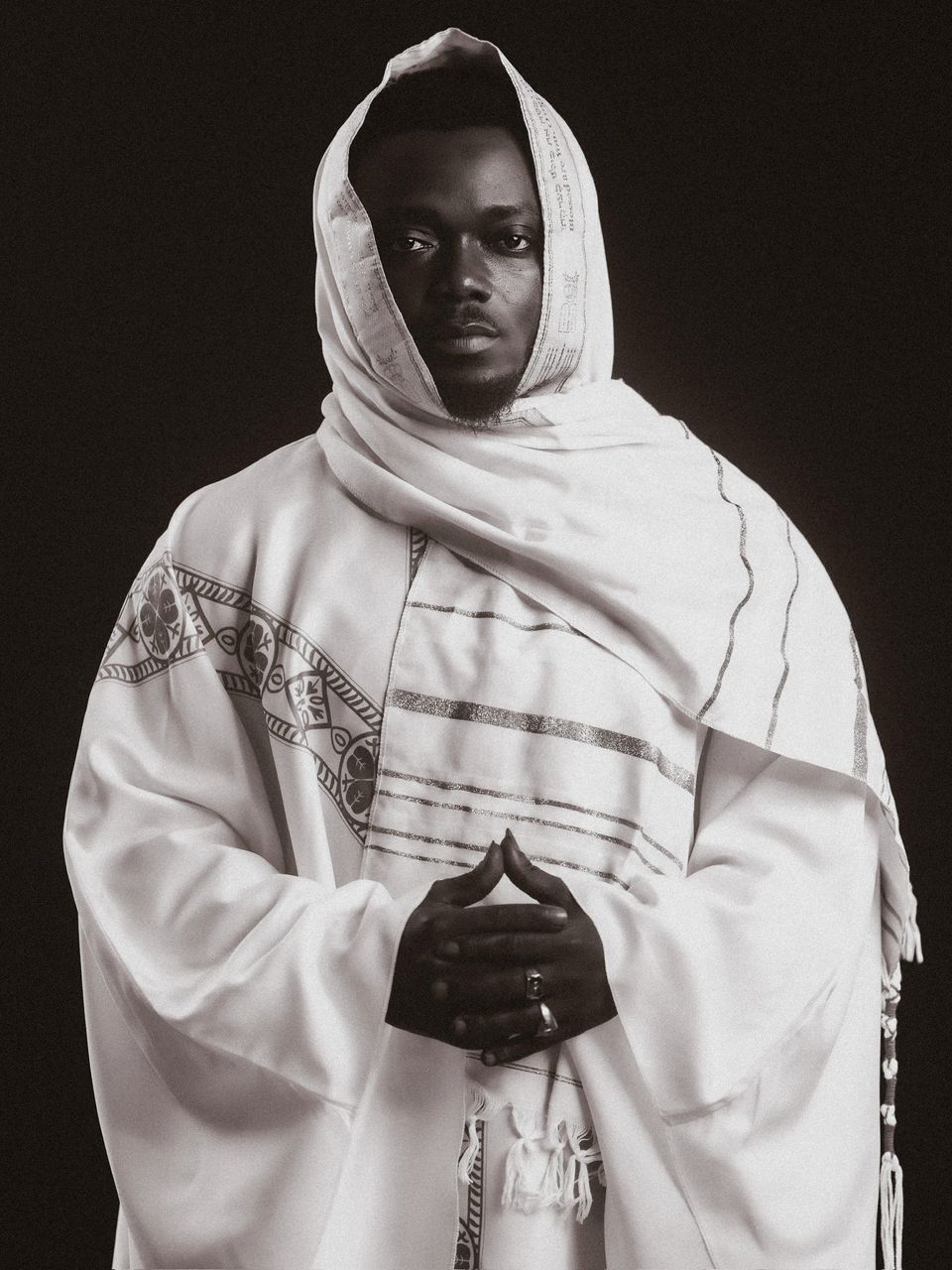 Pastor White in white prophetic garments, hands clasped in prayer — the spiritual portrait of the Founder of White Outreach Movement.