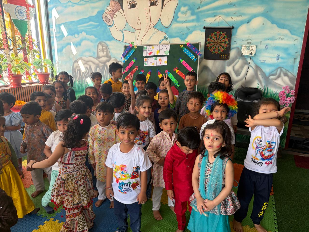 Students in traditional dress with Ganesha backdrop