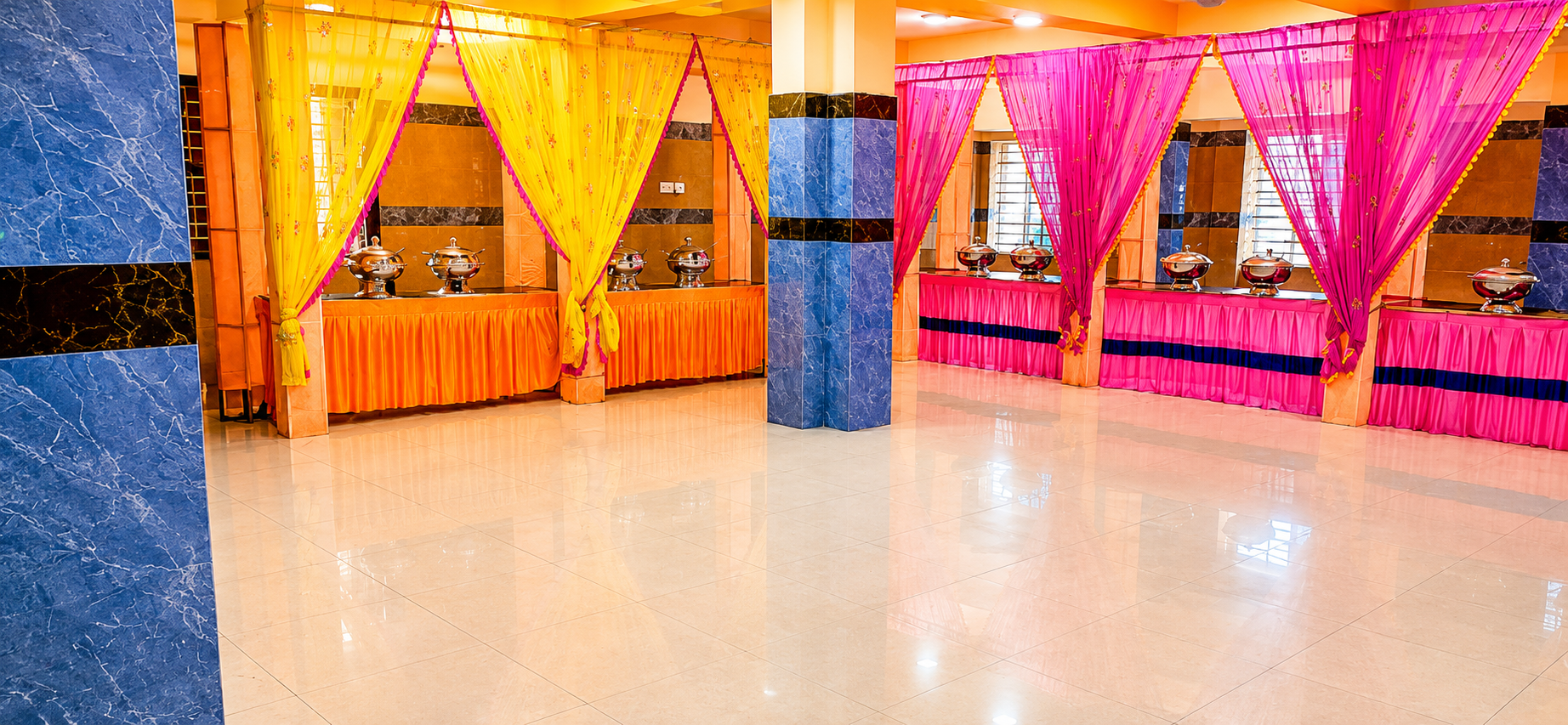 Vibrant yellow & pink draped buffet stations inside the hall