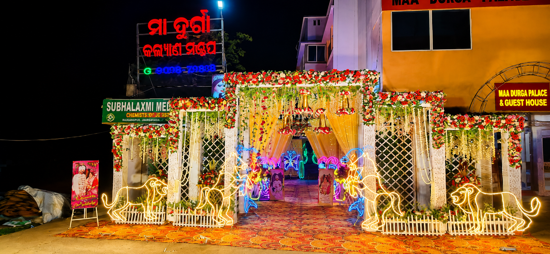 Maa Durga Kalyan Mandap night entrance with neon lions and butterfly lights