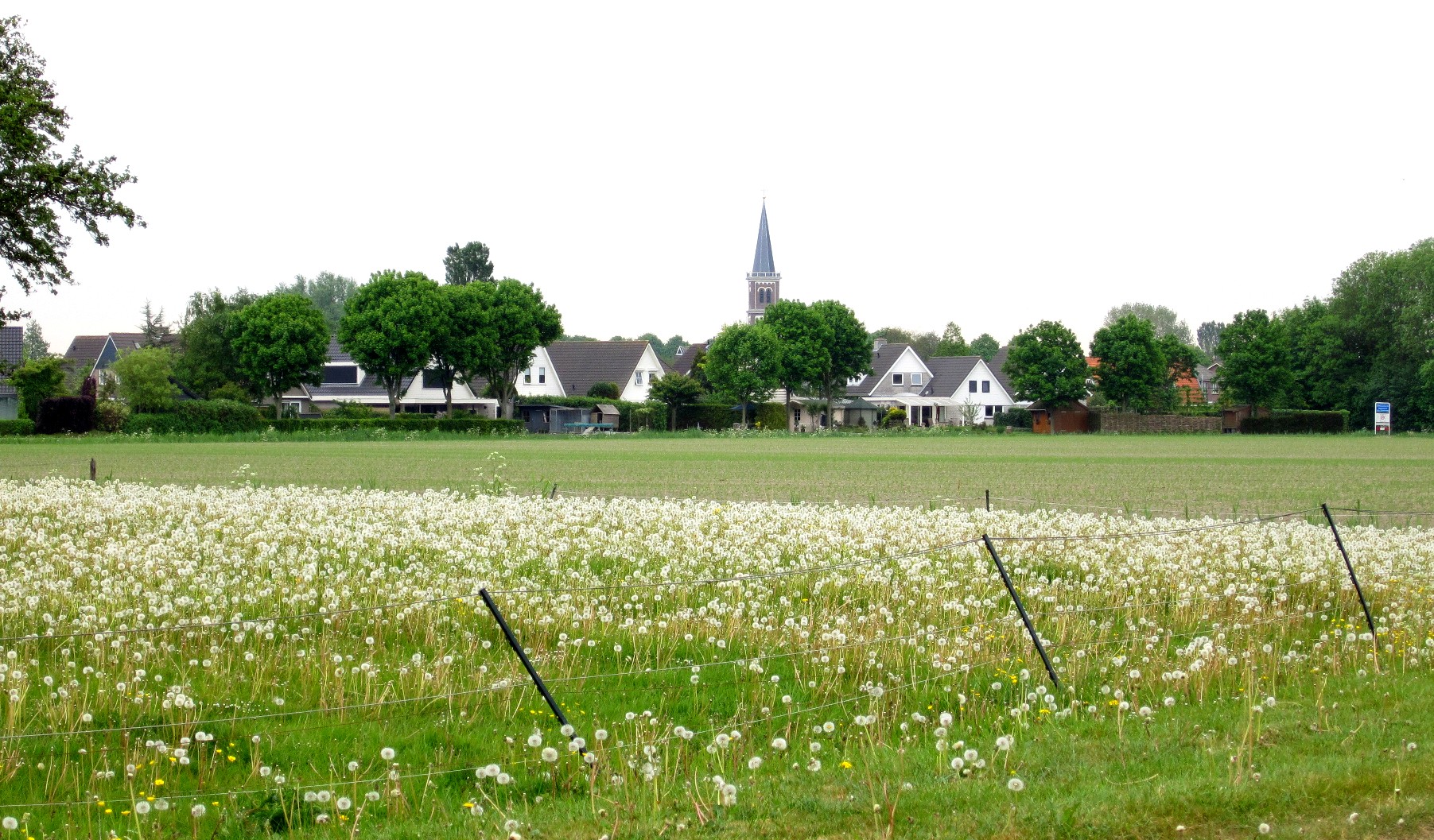 Het dorp Menaam met kerktoren onder een dramatische lucht