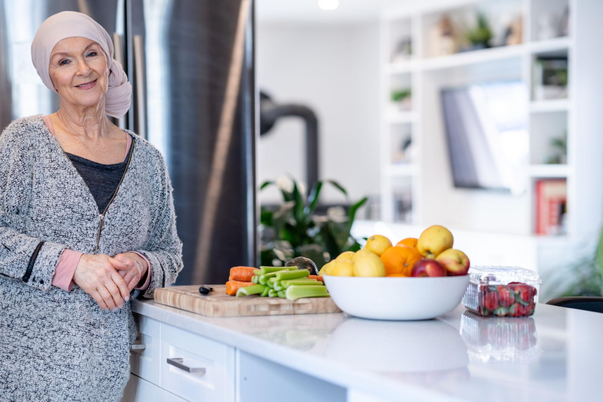 A dietitian standing next to fresh produce in her kitchen