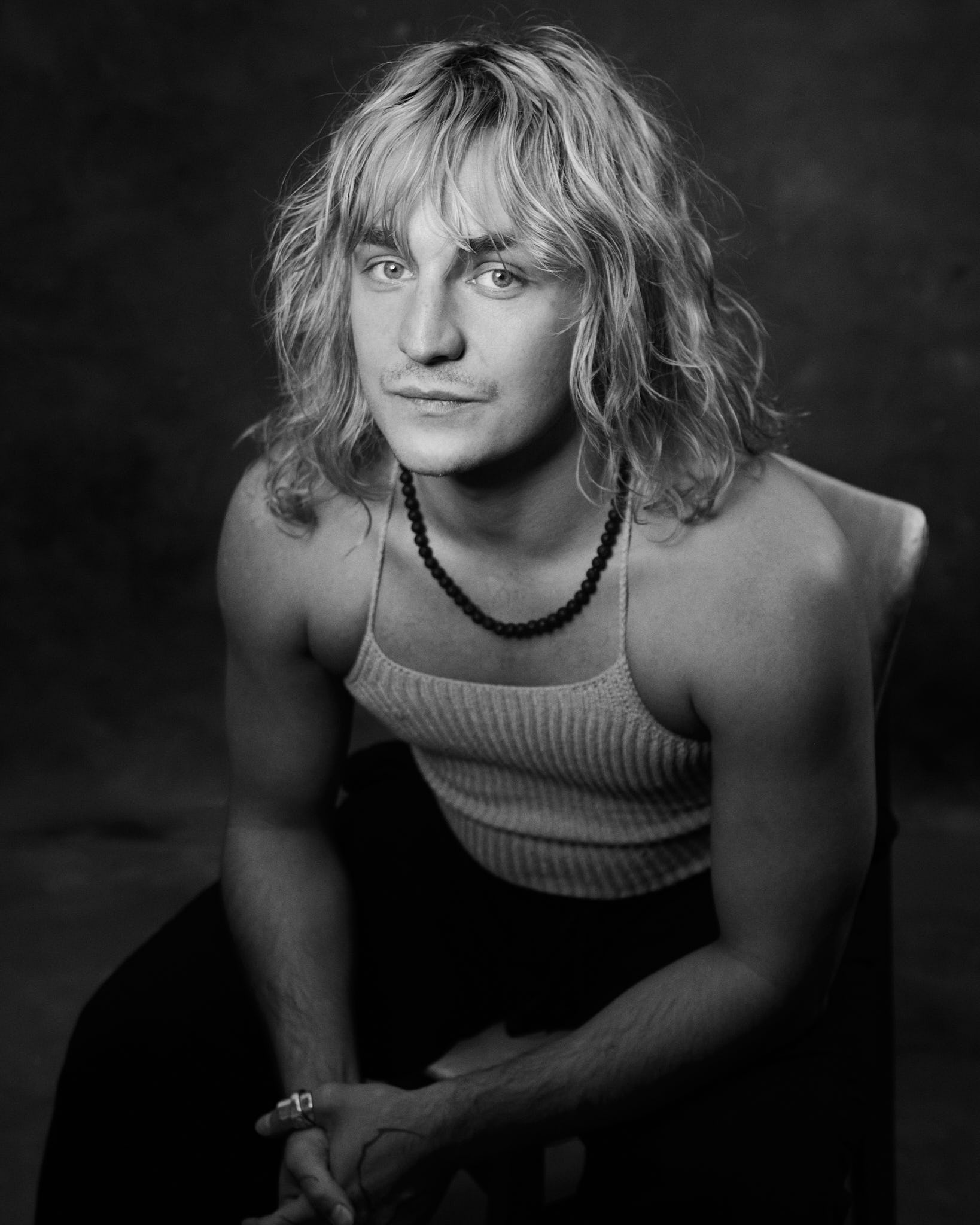 Black and white editorial headshot — long blonde wavy hair, neutral expression — shot at Peanut Factory Studio, Hackney Wick