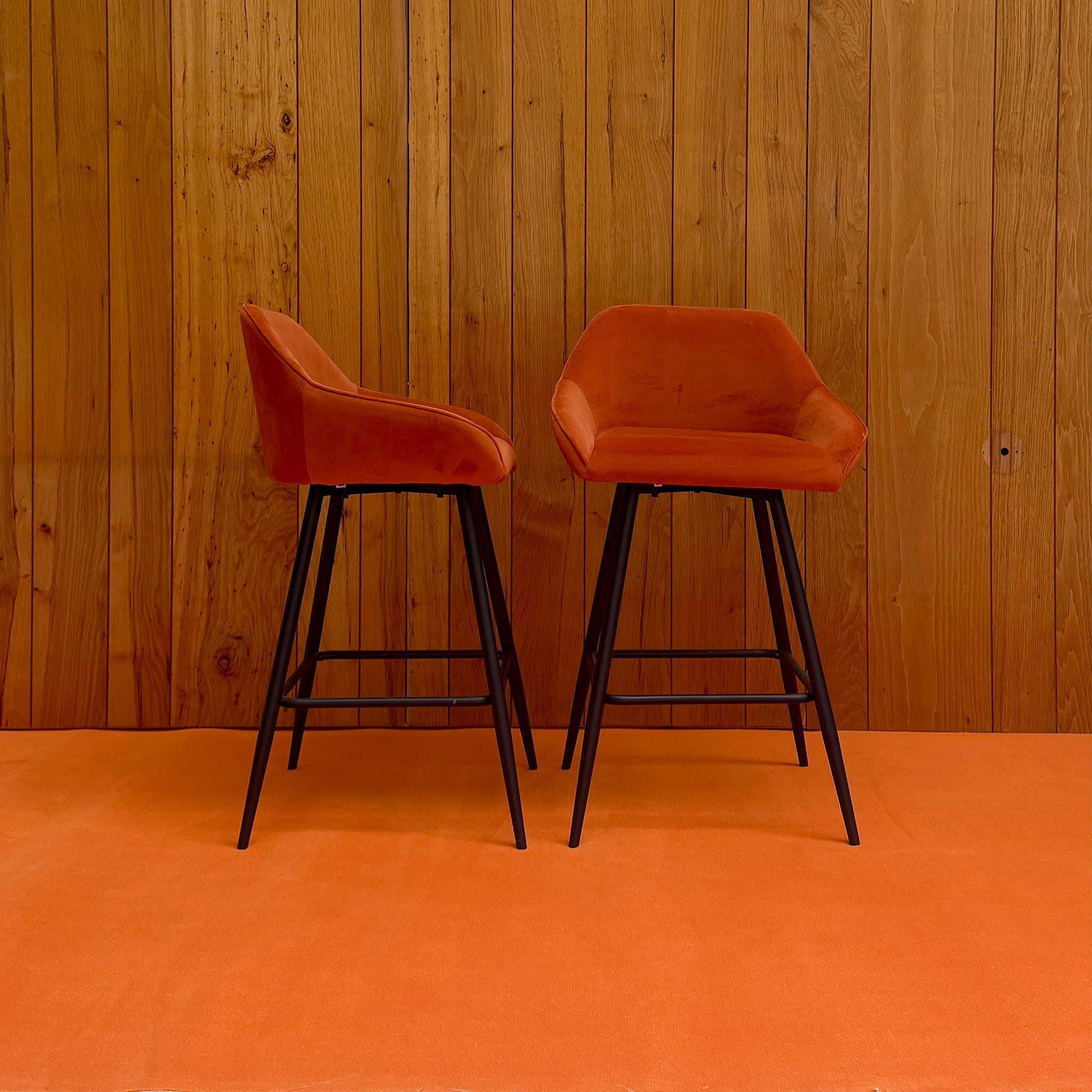 Pair of red plastic bar stools with black metal frame — available on-site at Peanut Factory Studio