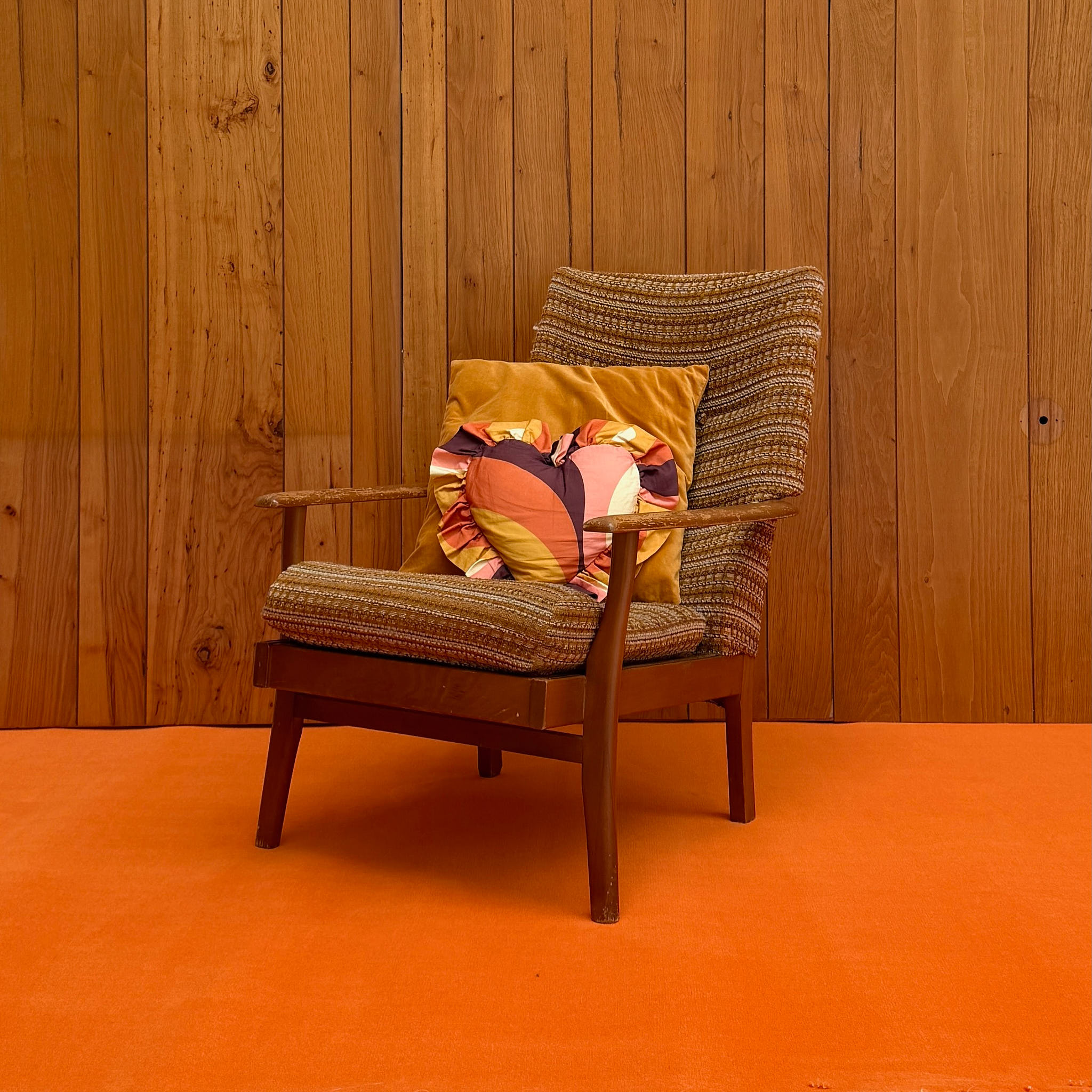 Vintage wood armchair with tweed cushion and patterned heart pillow — available on-site at Peanut Factory Studio