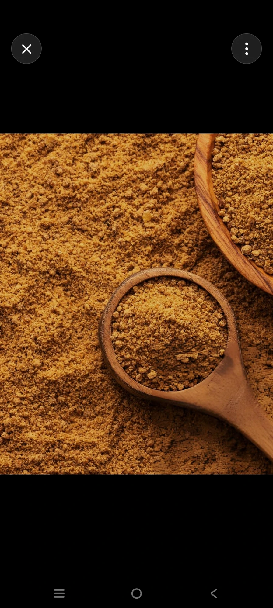 Natural jaggery powder in wooden scoop