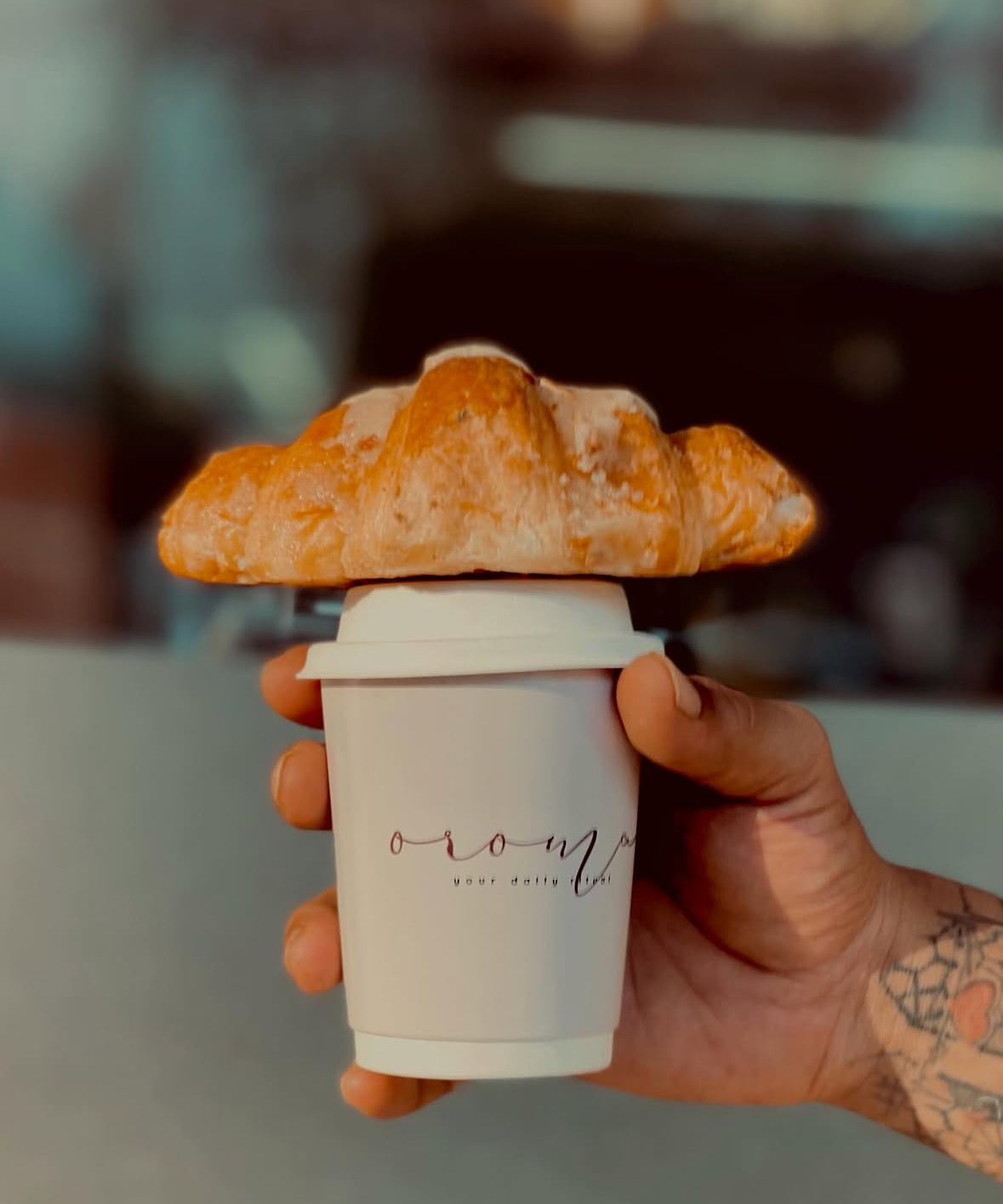 OROMA coffee cup with a fresh croissant