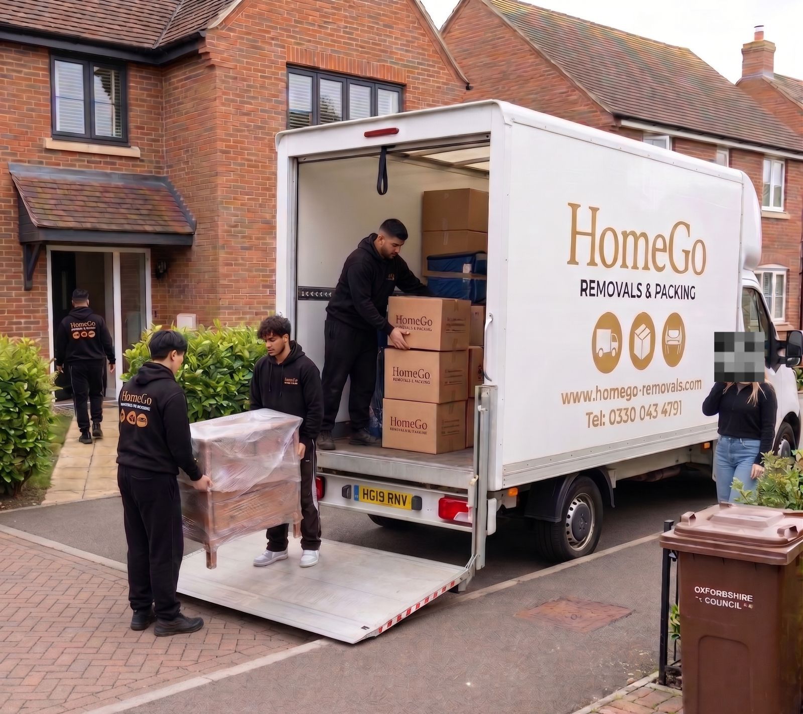 HomeGo Removals crew unloading boxes at a detached family home outside London
