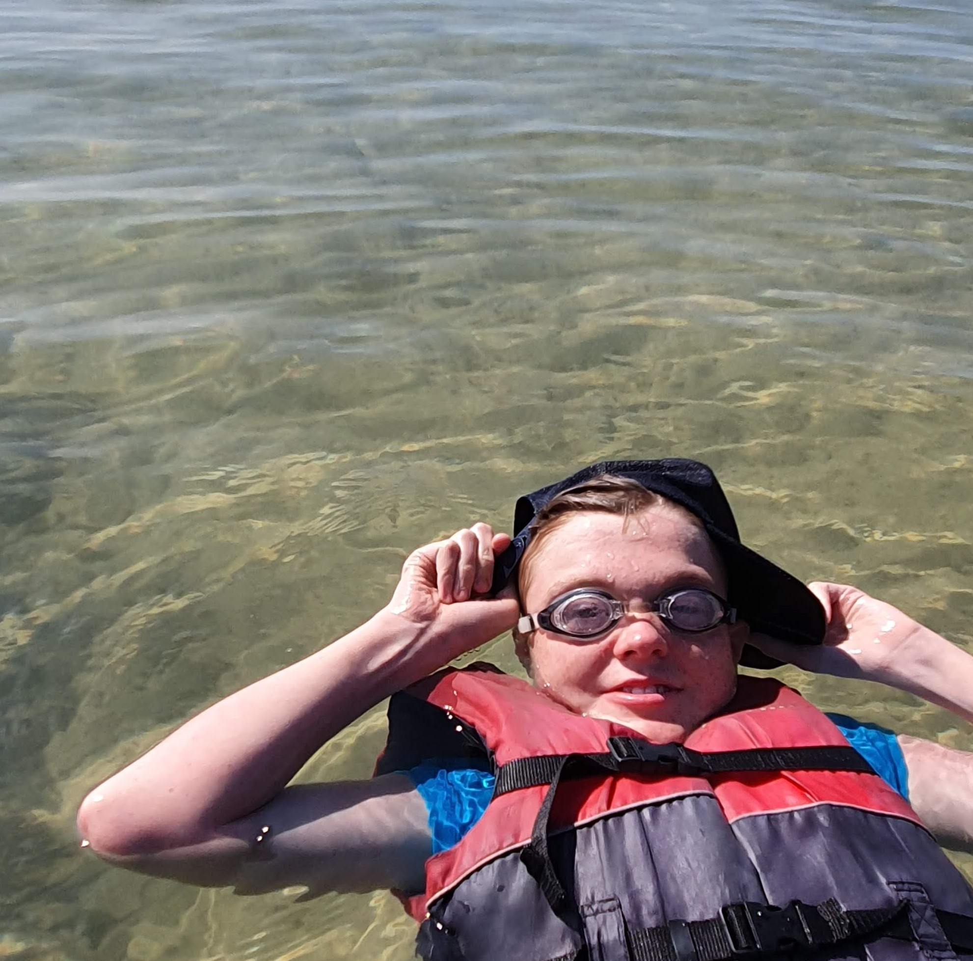 A PeerWave participant floating happily in clear water