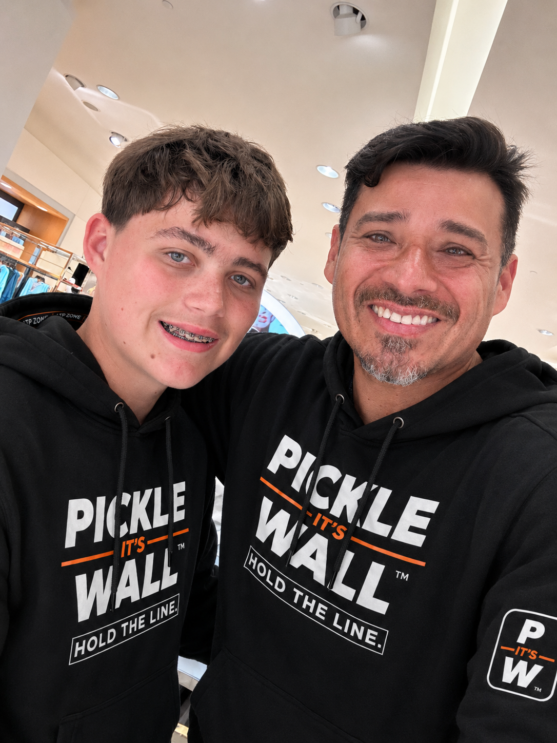 Juan Carlos Diaz and his son Jamieson wearing Pickle Wall hoodies