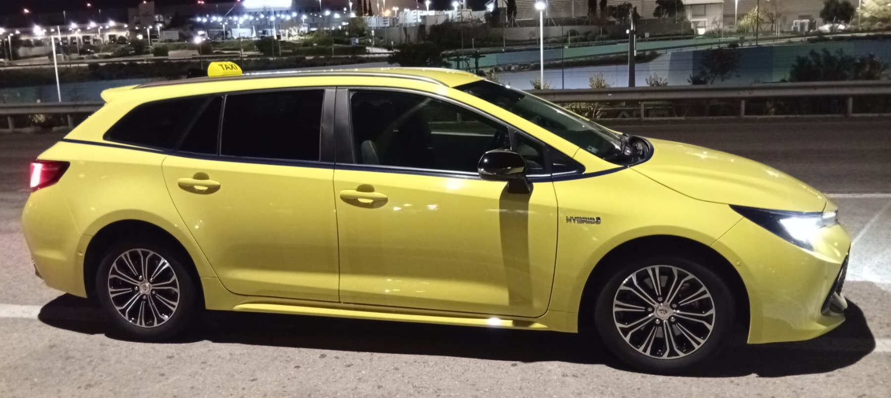 Our yellow Toyota Hybrid taxi at night