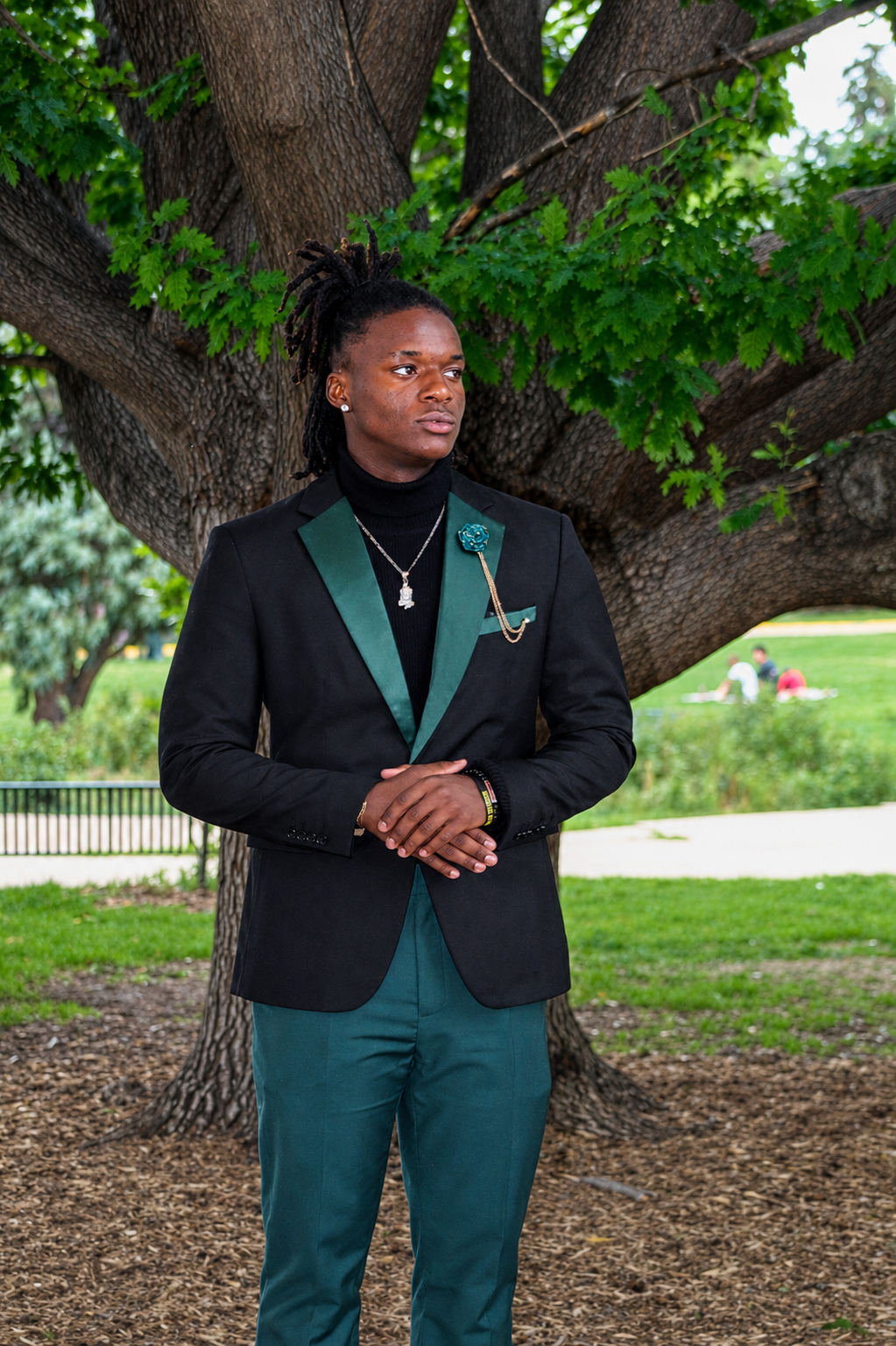 Senior solo · emerald-trim tuxedo under the oak tree