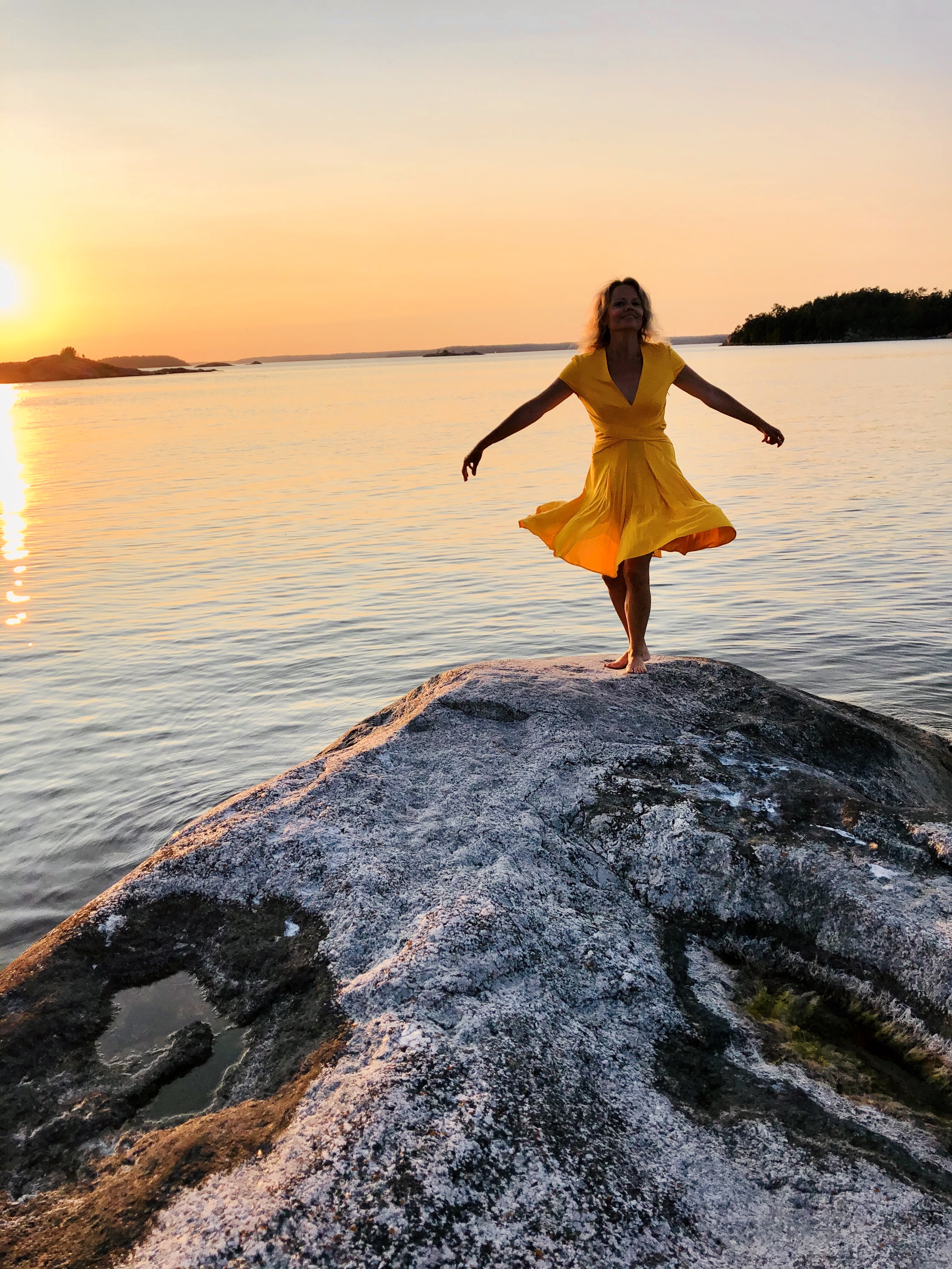 Carla embracing life and wellness by the sea at sunset