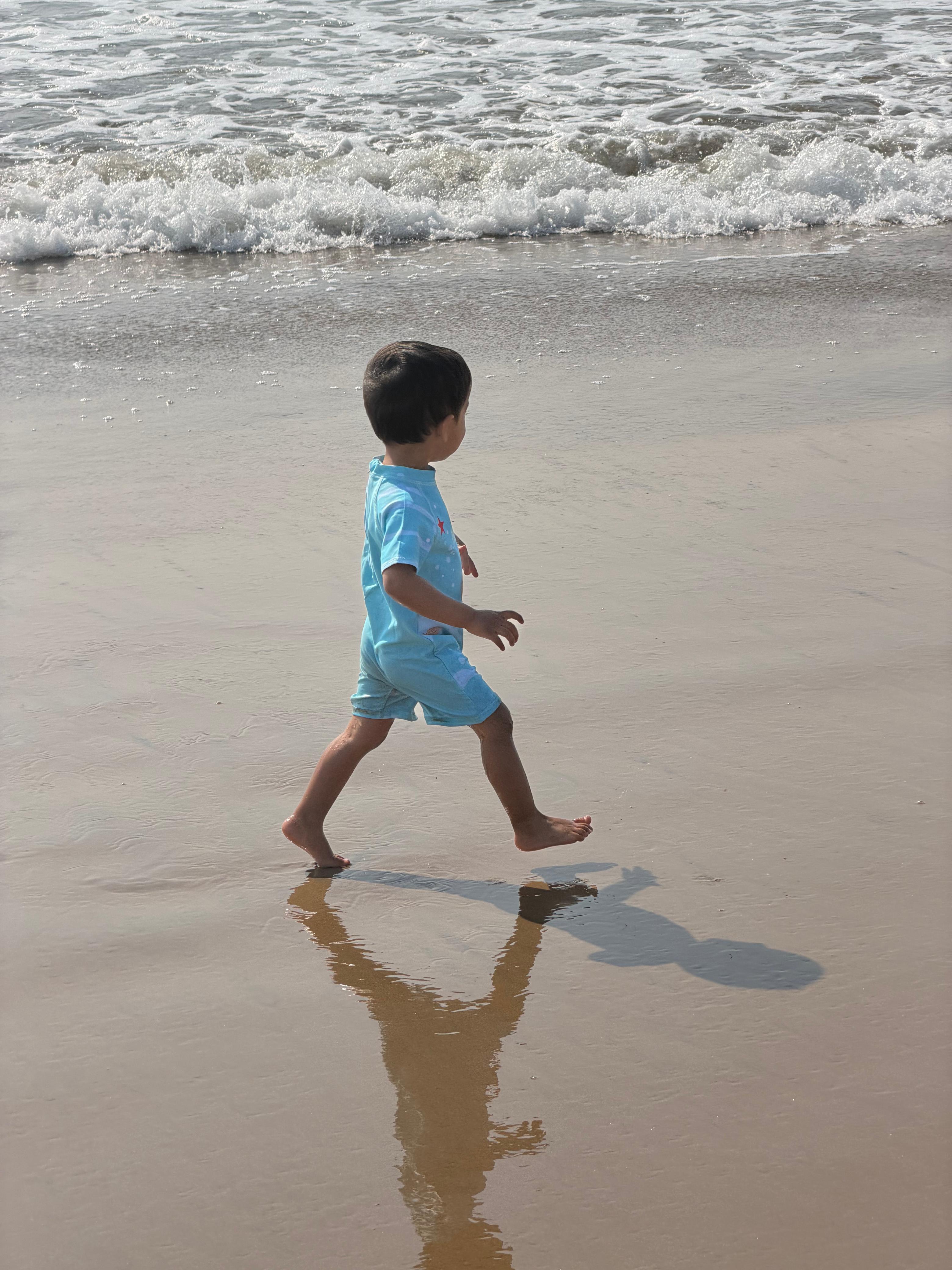 A child runs along the shoreline at Cala Macarella