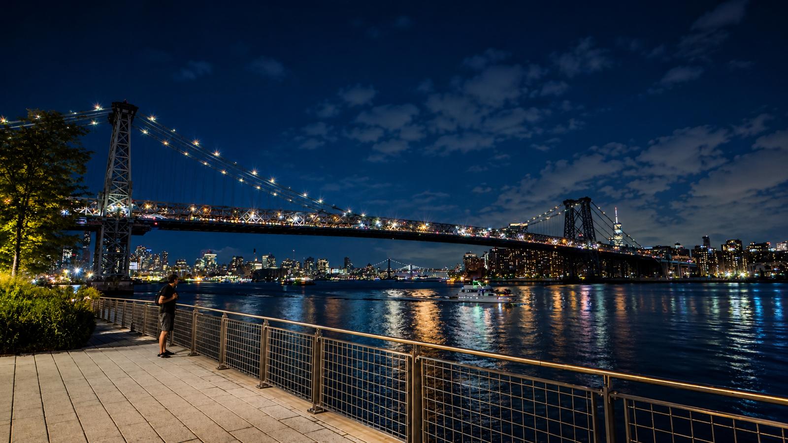 Puente de Williamsburg sobre el East River con la silueta del skyline de Nueva York al fondo