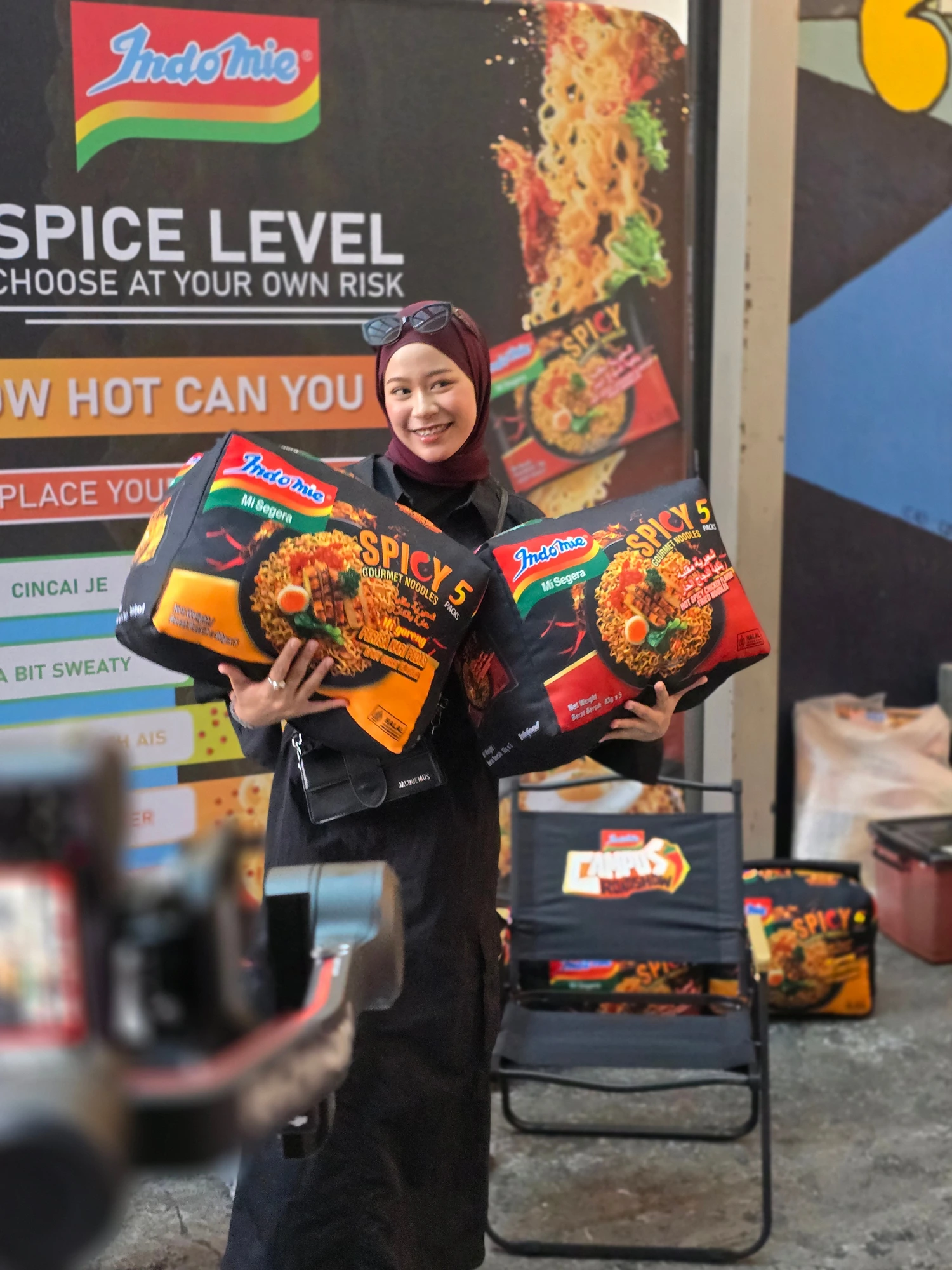 Indomie campus roadshow participant holding branded product displays