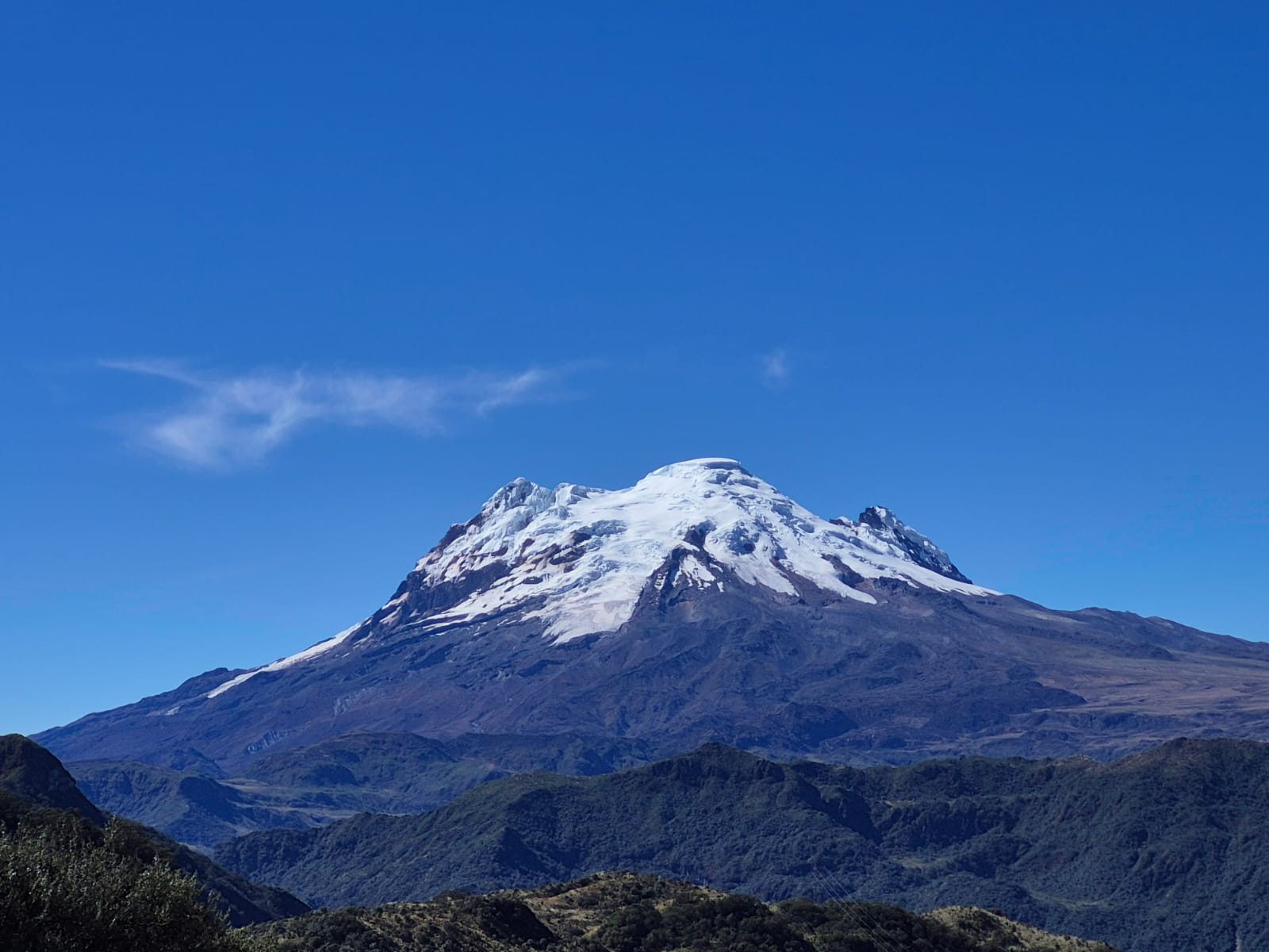 Protected-area wildlife-crossing sign on the road to Papallacta, with Antisana volcano beyond