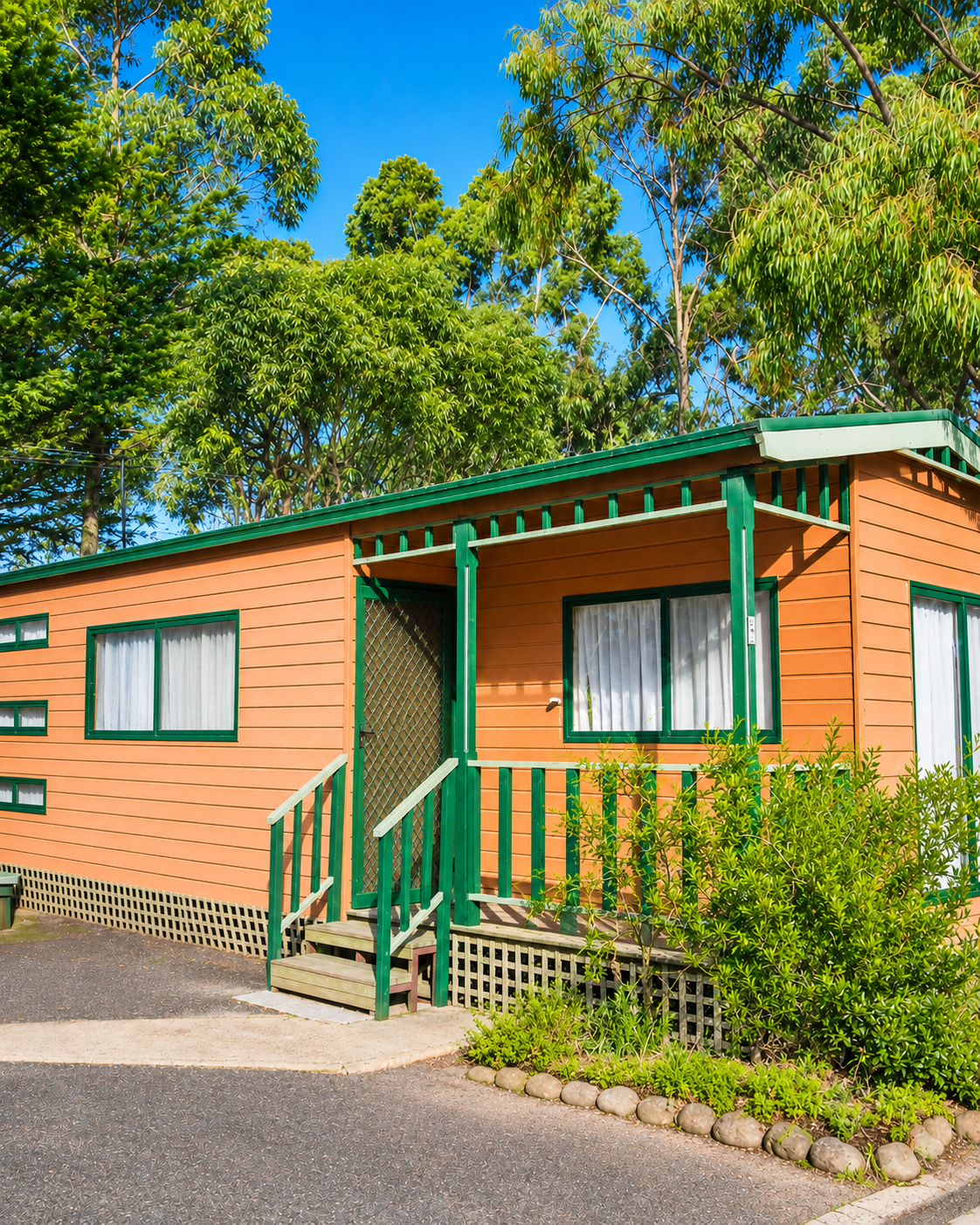 Heritage orange cabin with green trim and front porch