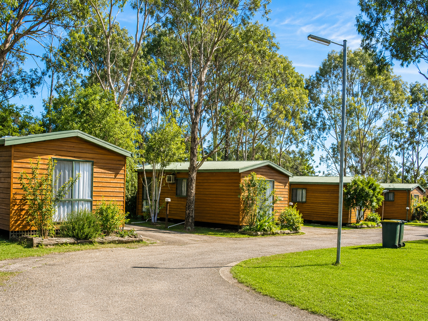 Row of timber tourist cabins set among gum trees at Shady Acres