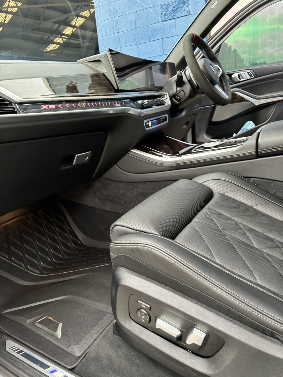 BMW X5 driver cockpit — alcantara wheel and curved display