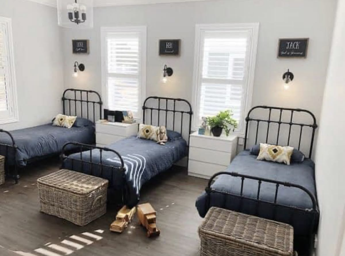A bright, welcoming shared bedroom with three twin beds at Beds of Haven