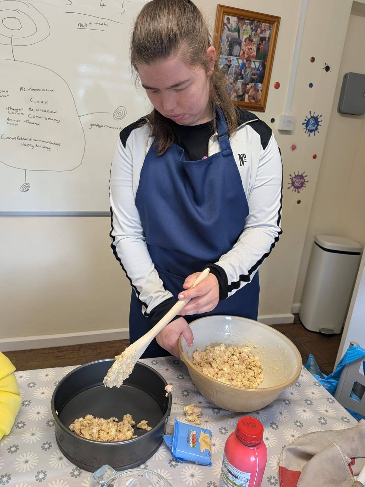 Someone we support proudly presenting a homemade pizza they prepared in a cooking session.