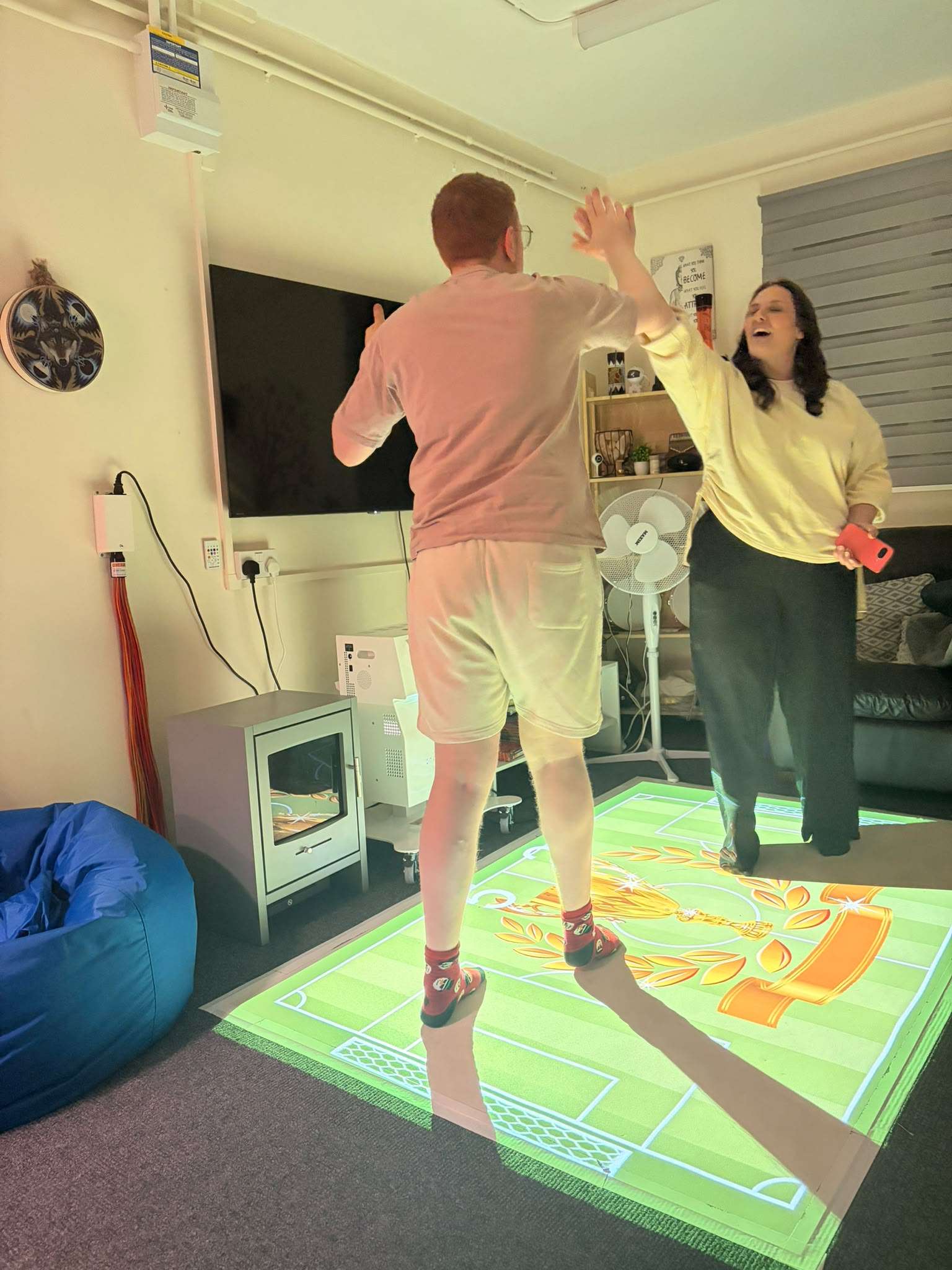 Two people we support enjoying an interactive sensory light floor game.