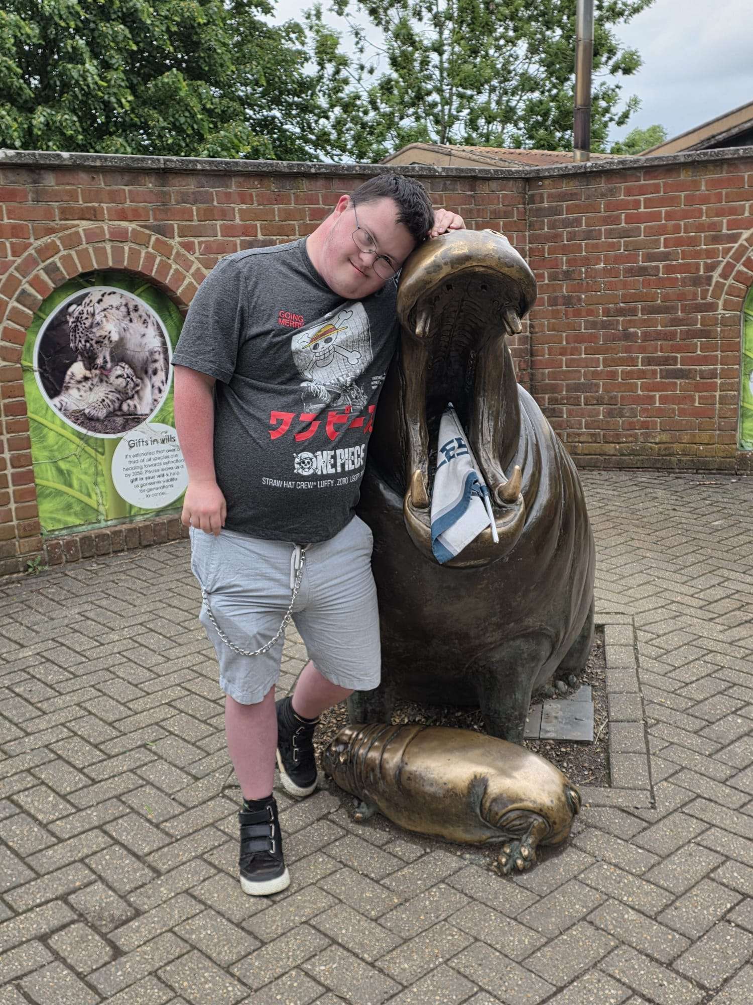 Someone we support posing with a hippo sculpture at a wildlife park.