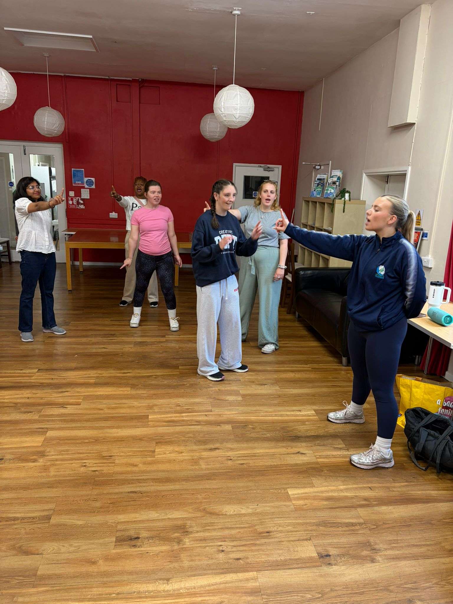 People we support taking part in an energetic dance and performance class with an instructor.