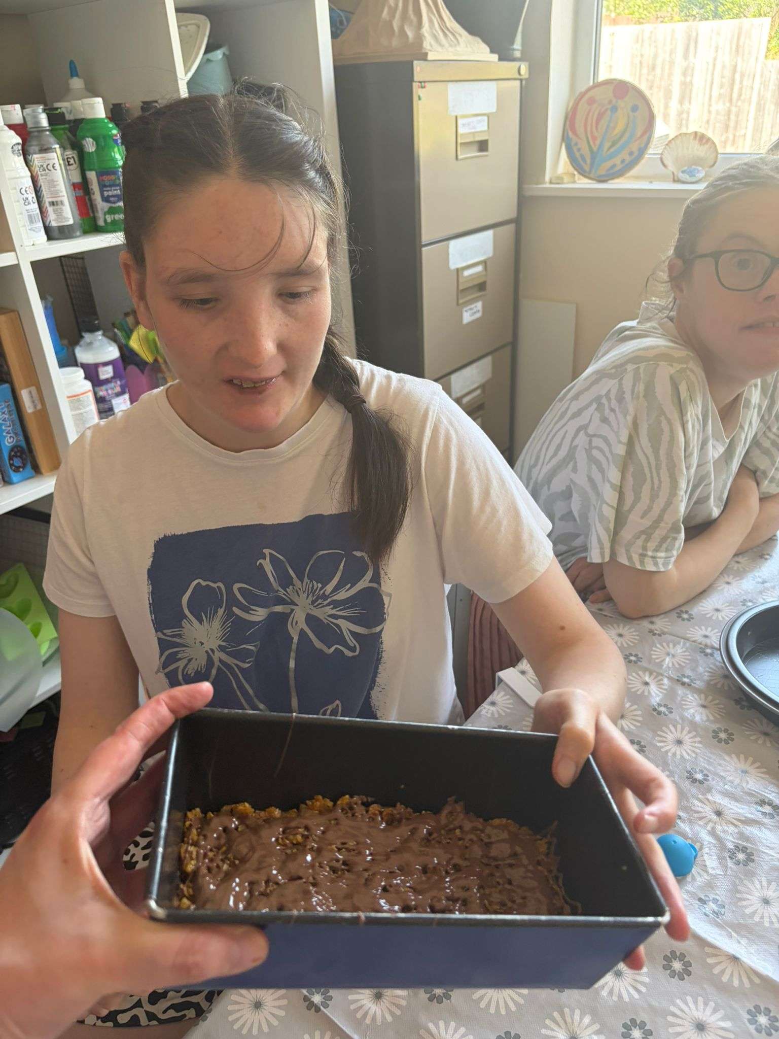 Someone we support proudly showing the chocolate tray bake they made during a cooking session.