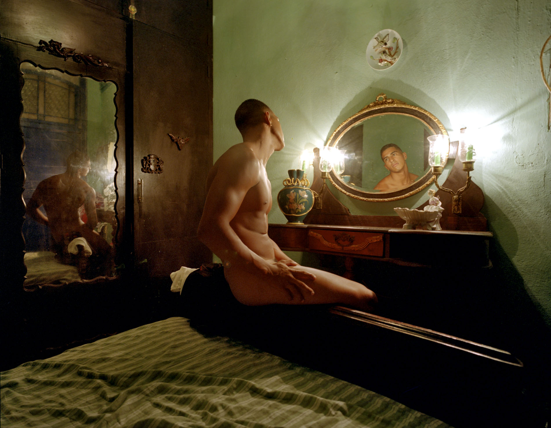 Image from Cuba, Love Story by Kobi Israel — interior, candle-lit room with mirrors. Details to be confirmed.