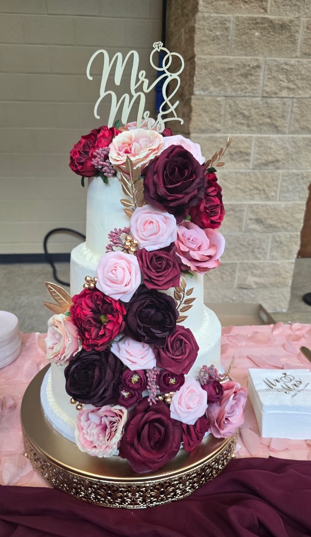 Three-tier ivory wedding cake with cascading burgundy and blush roses, Mr & Mrs topper