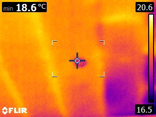 Wall / floor junction — cooler band where the slab meets the wall, evidence of perimeter heat-loss path that the report recommends targeting with perimeter insulation