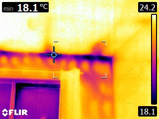 Top of door frame — pronounced cold band consistent with air leakage around the lintel