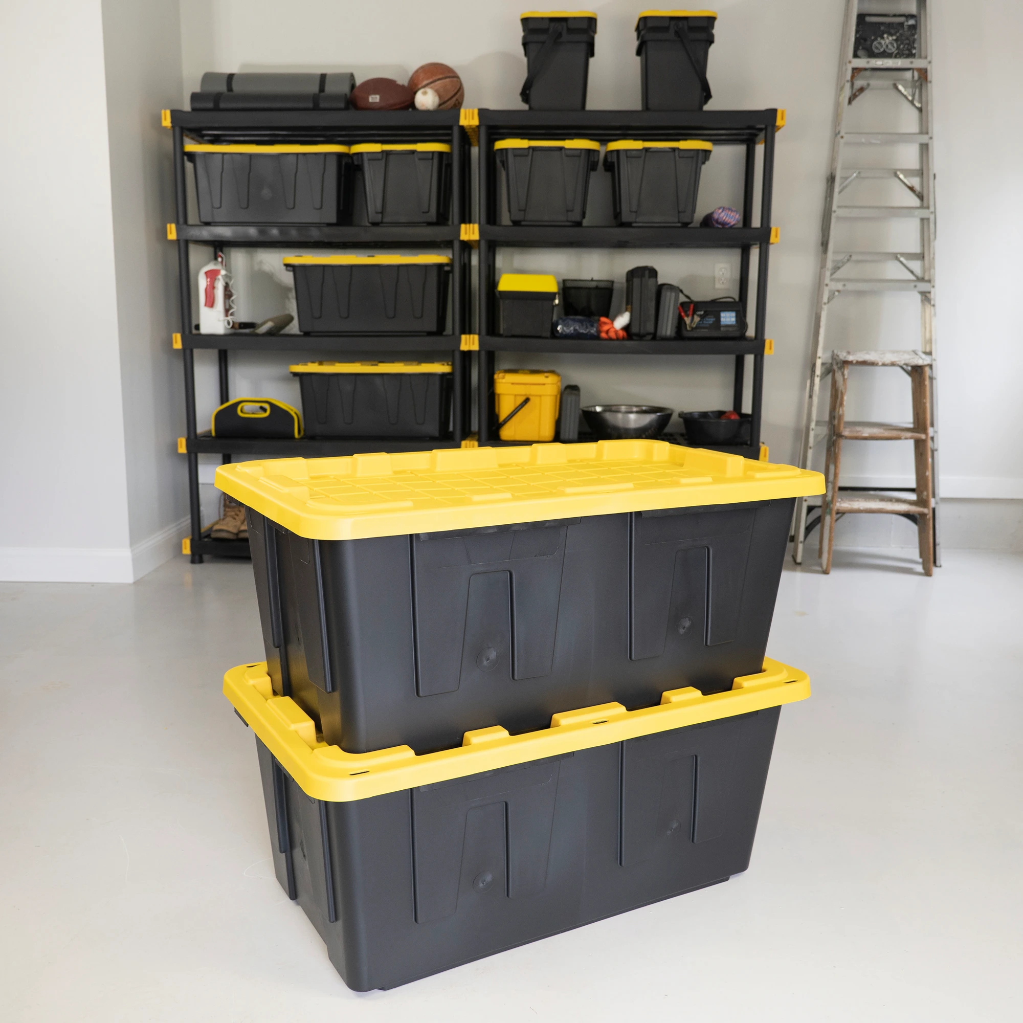 Stacked black-and-yellow ToteHaul moving totes in a clean garage next to shelving of more totes