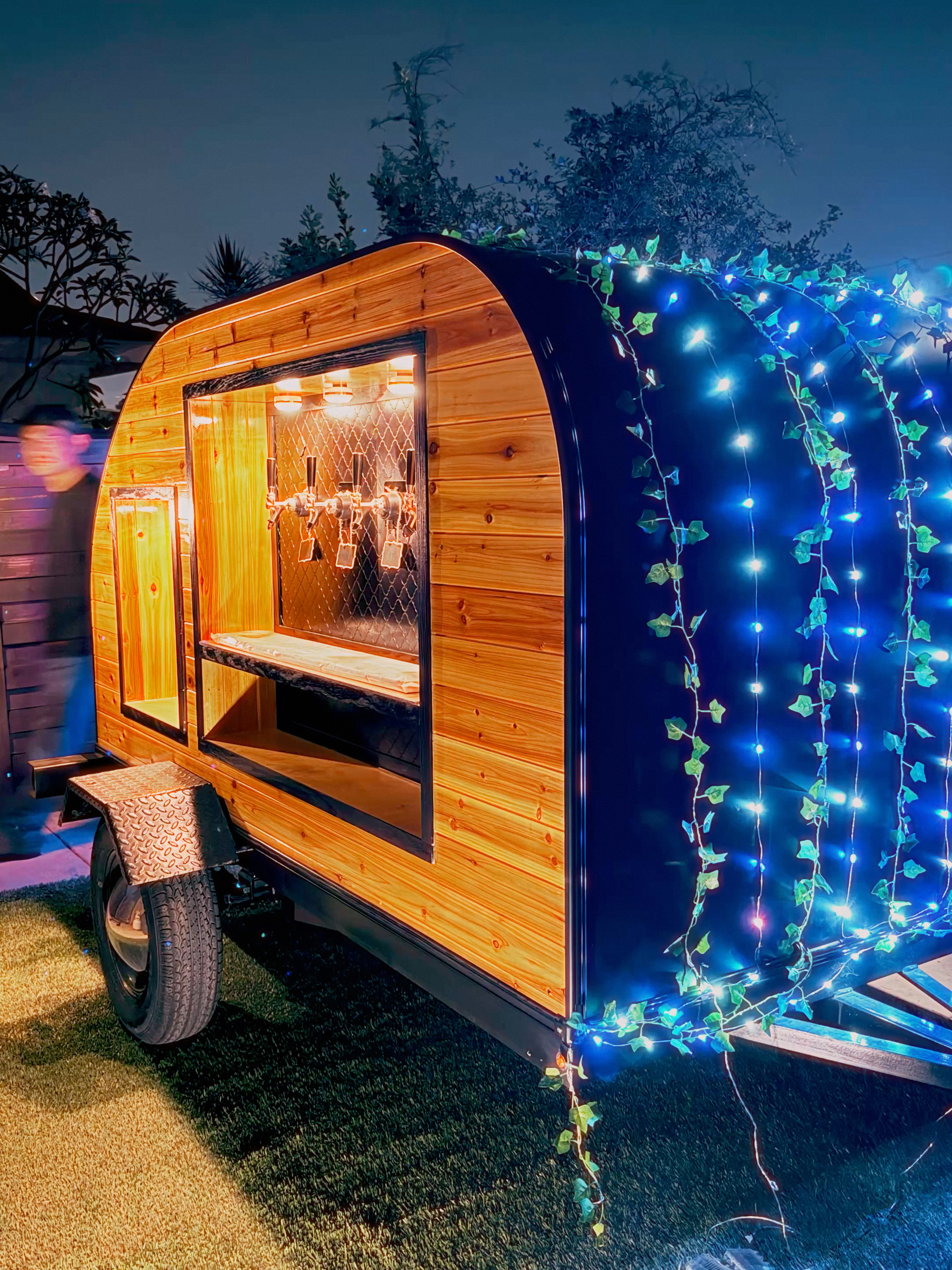 Trailhead Taps trailer at night with fairy lights