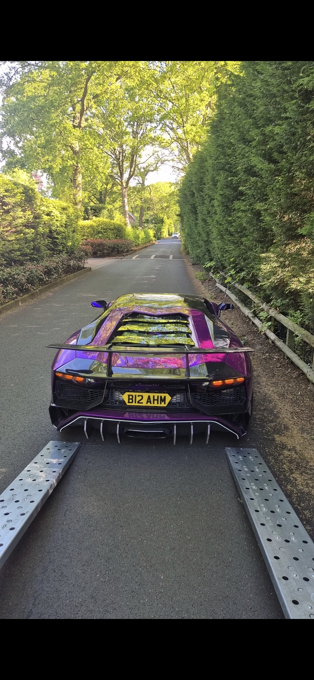 Luxury car being loaded onto an enclosed transporter