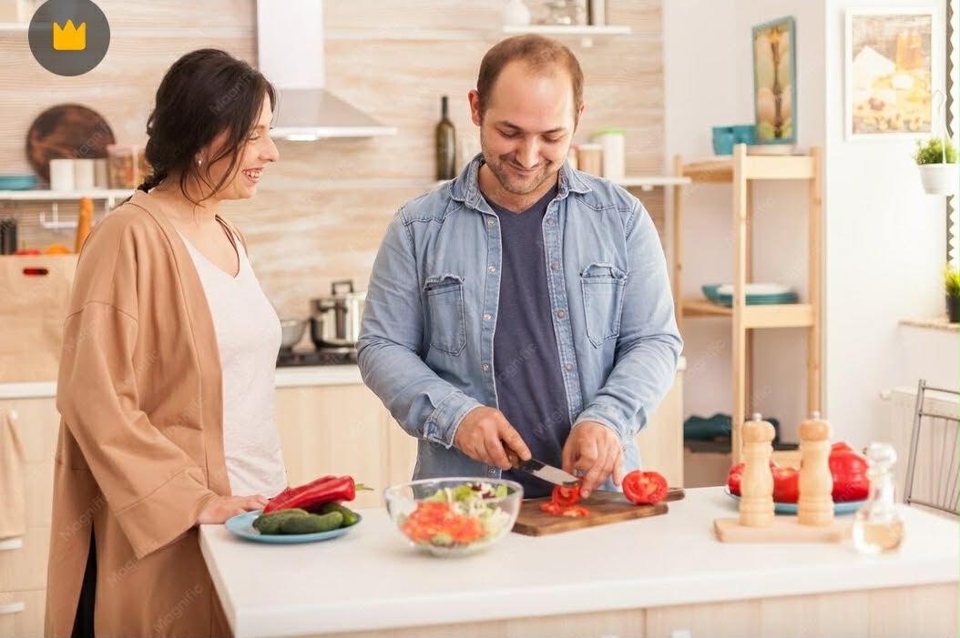 Young adult participant cooking in a bright kitchen with their support worker