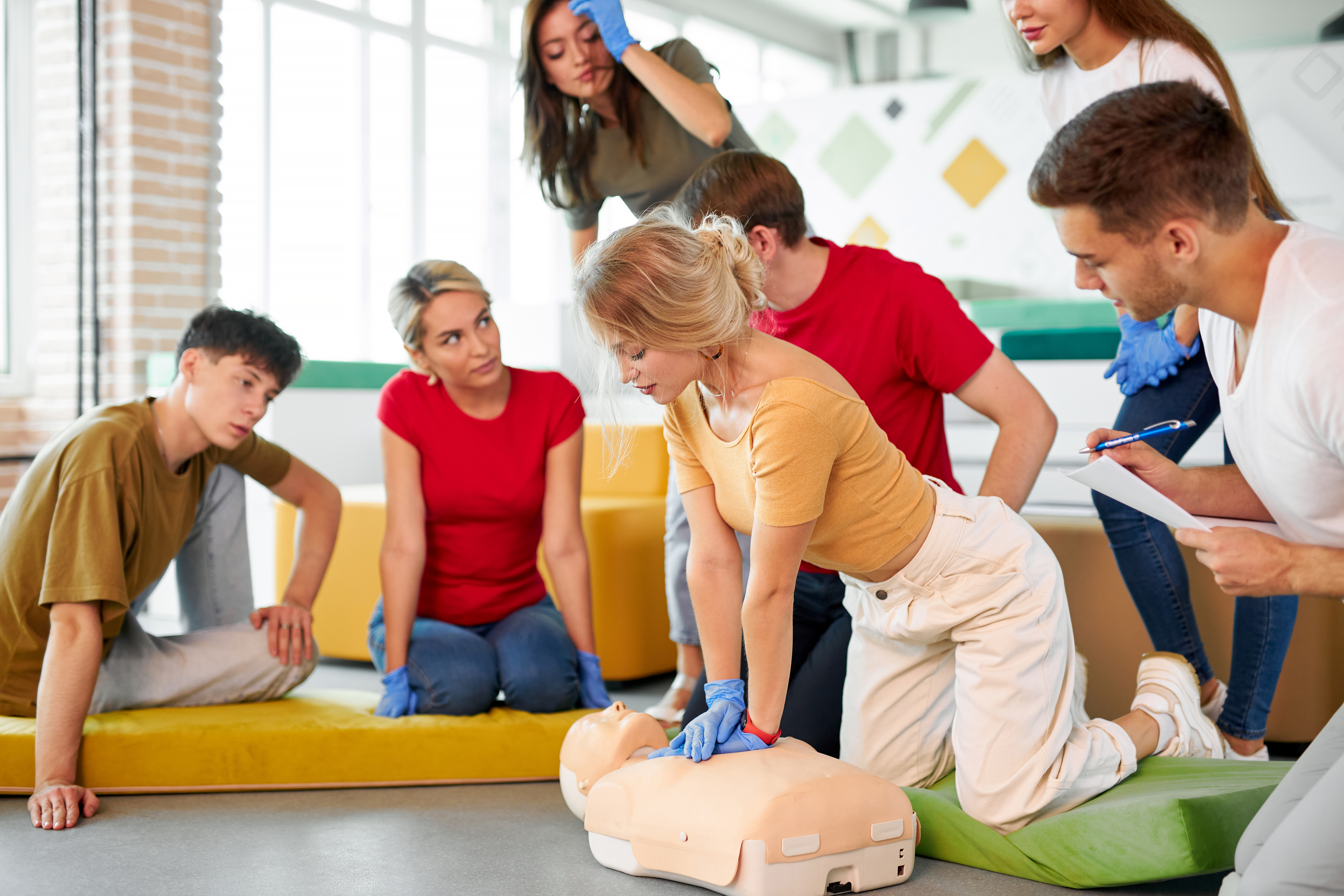 Istruttrice 7MED che dimostra l'uso di un defibrillatore AED durante un corso BLS-AED in Ticino