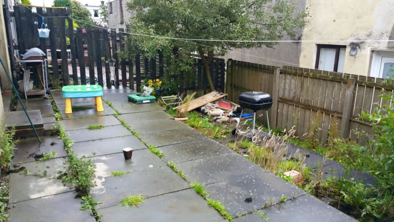 Real before — overgrown garden with old paving slabs, before Last Cut Landscaping transformation